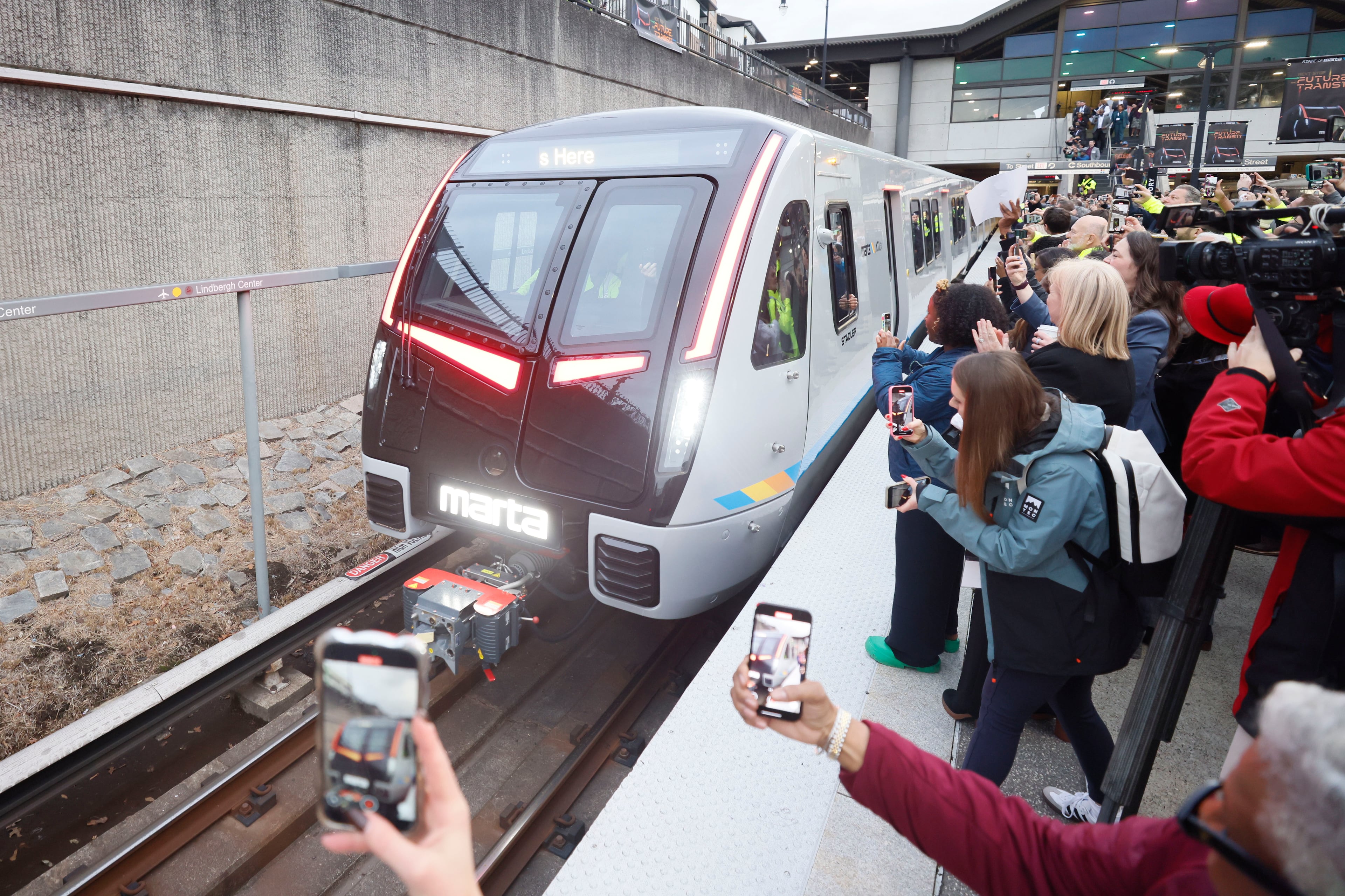 Members of the press and guests record the arrival of the new MARTA train at Lindbergh station on Thursday, Jan. 30, 2025, in Atlanta. The transit agency is in the process of replacing its aging fleet of train cars. (Miguel Martinez/AJC 2025)