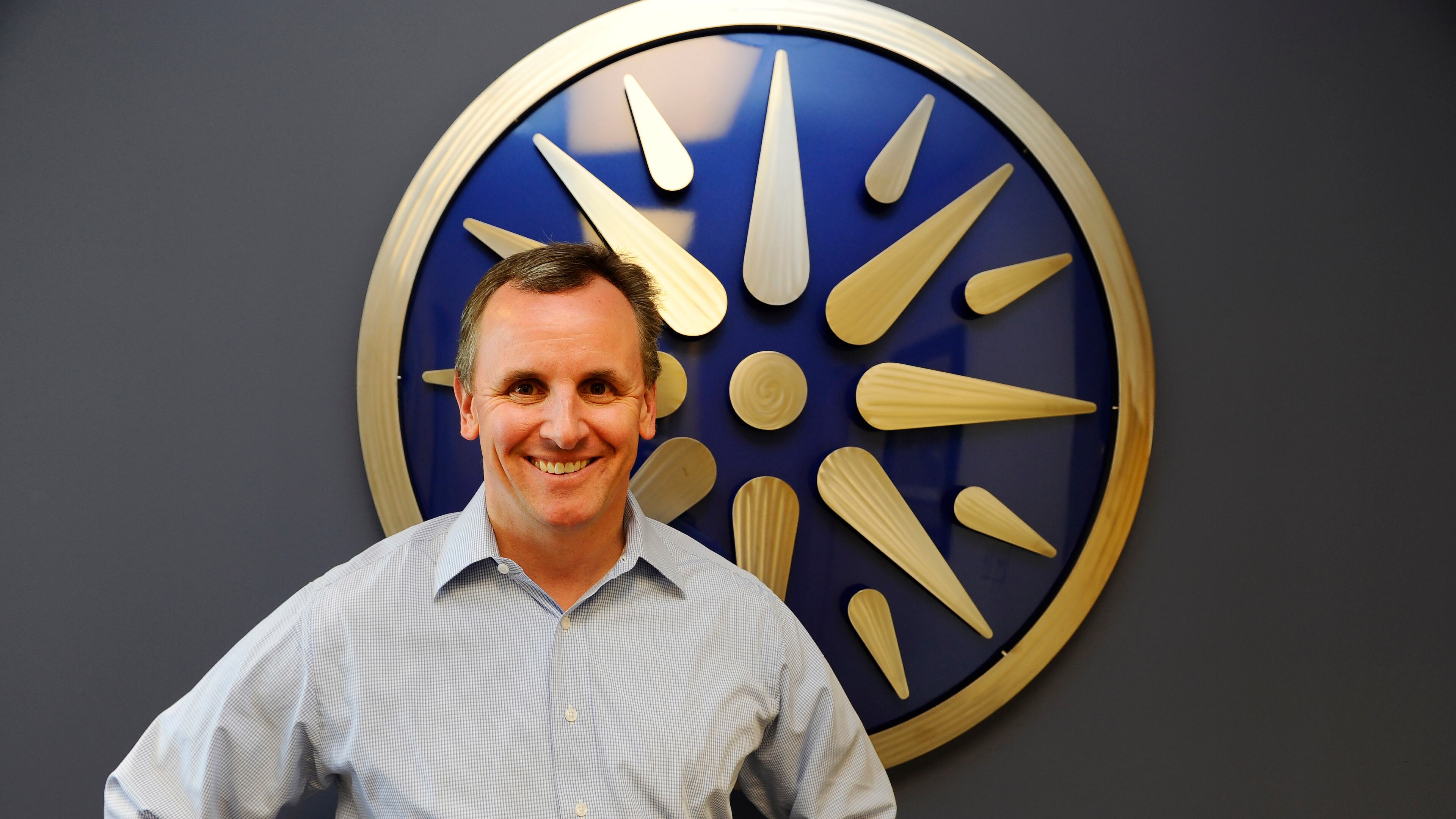 Insight Sourcing Group CEO Tom Beaty stands by his company's distinctive round logo at the firm's Norcross headquarters.