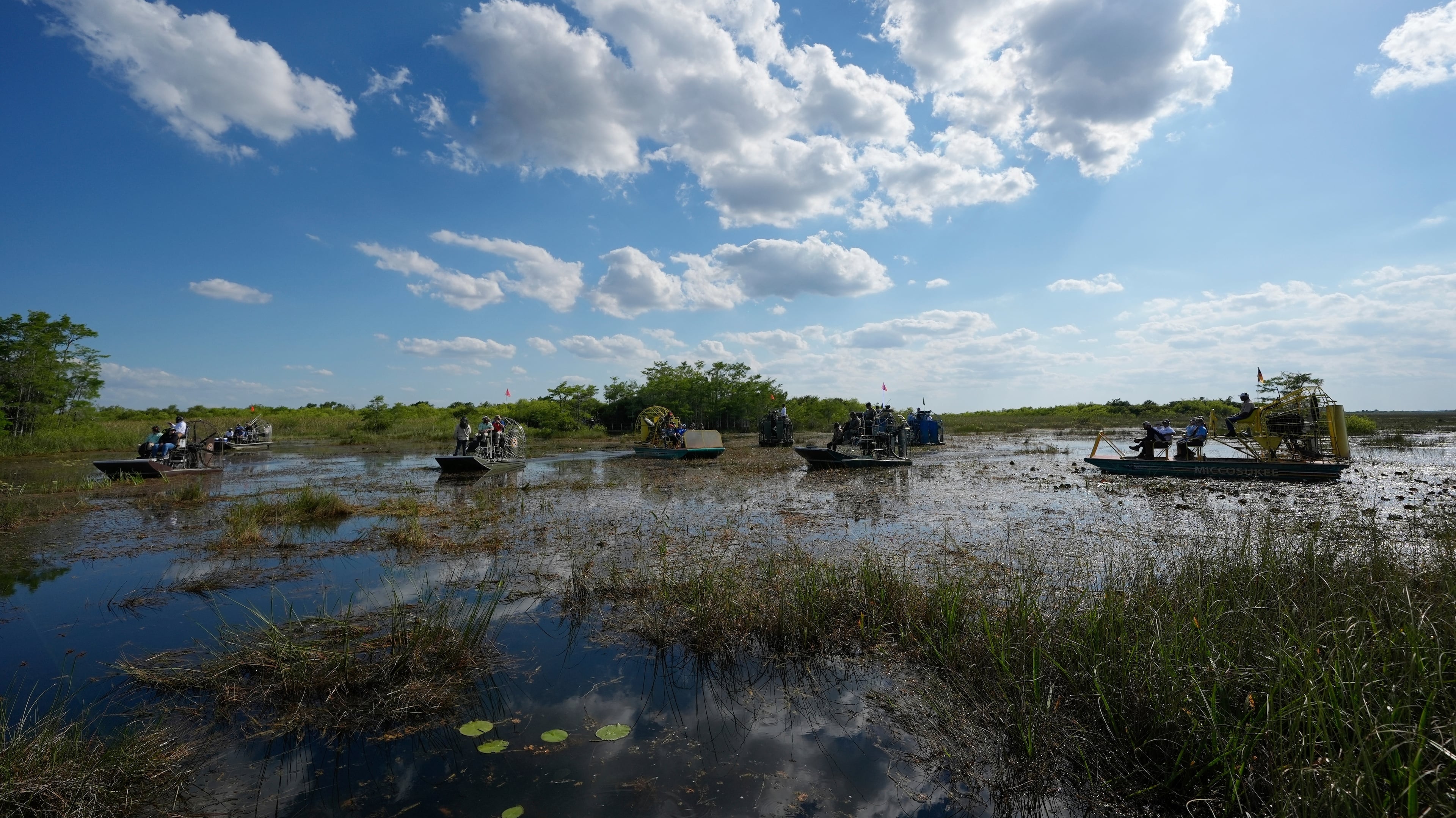 FILE - Airboats carry members of a task force that brings together federal, state, tribal and local agencies working to restore and protect the Florida Everglades, on a field visit to the Miccosukee Indian Reservation ahead of a task force meeting hosted by the Miccosukee Tribe, April 24, 2024. (AP Photo/Rebecca Blackwell, File)