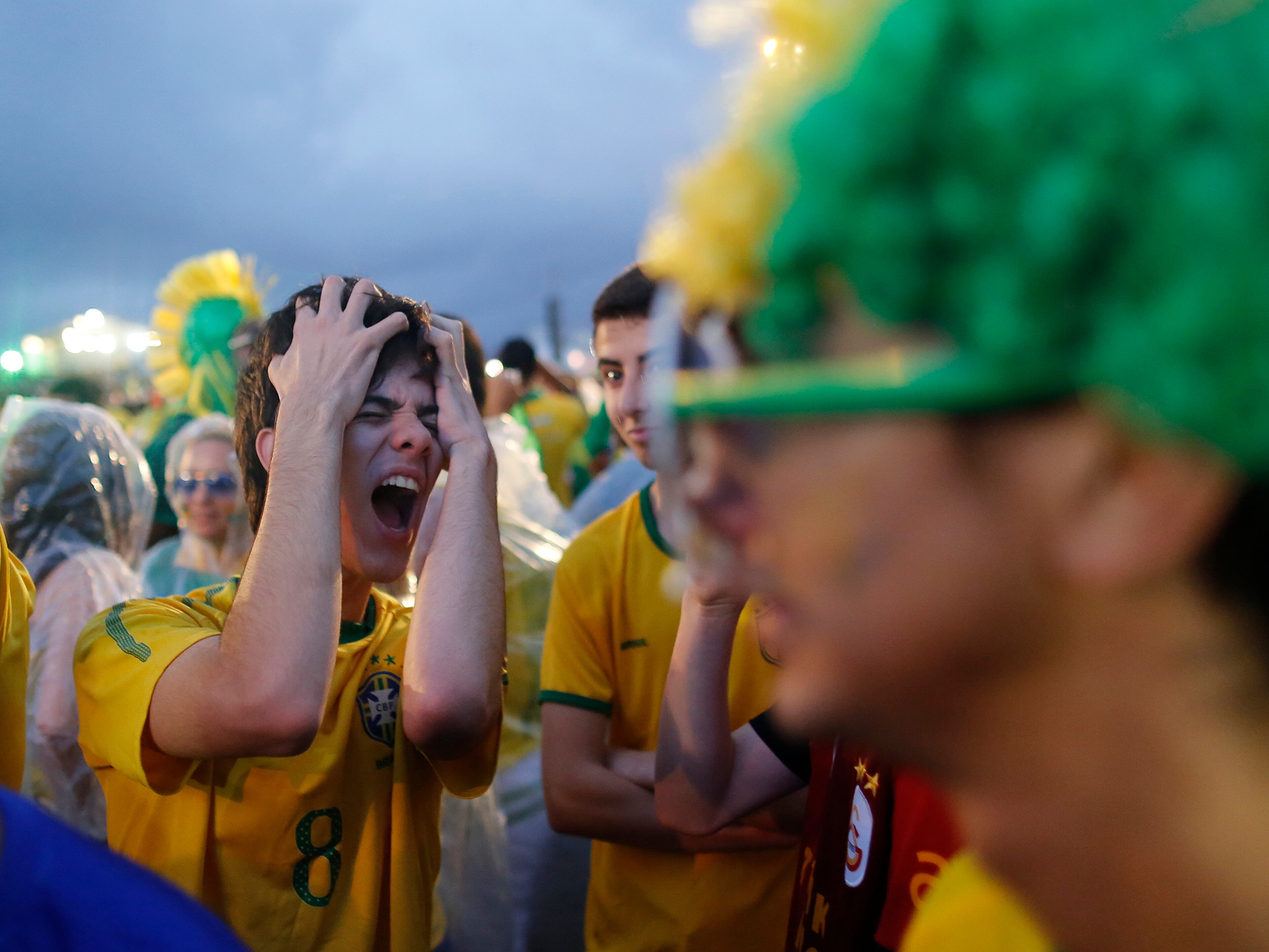 A Brazil soccer fan reacts in frustration as he watches his team play a World Cup semifinal match against Germany on a live telecast inside the FIFA Fan Fest area on Copacabana beach in Rio de Janeiro, Brazil, Tuesday, July 8, 2014. (AP Photo/Leo Correa)