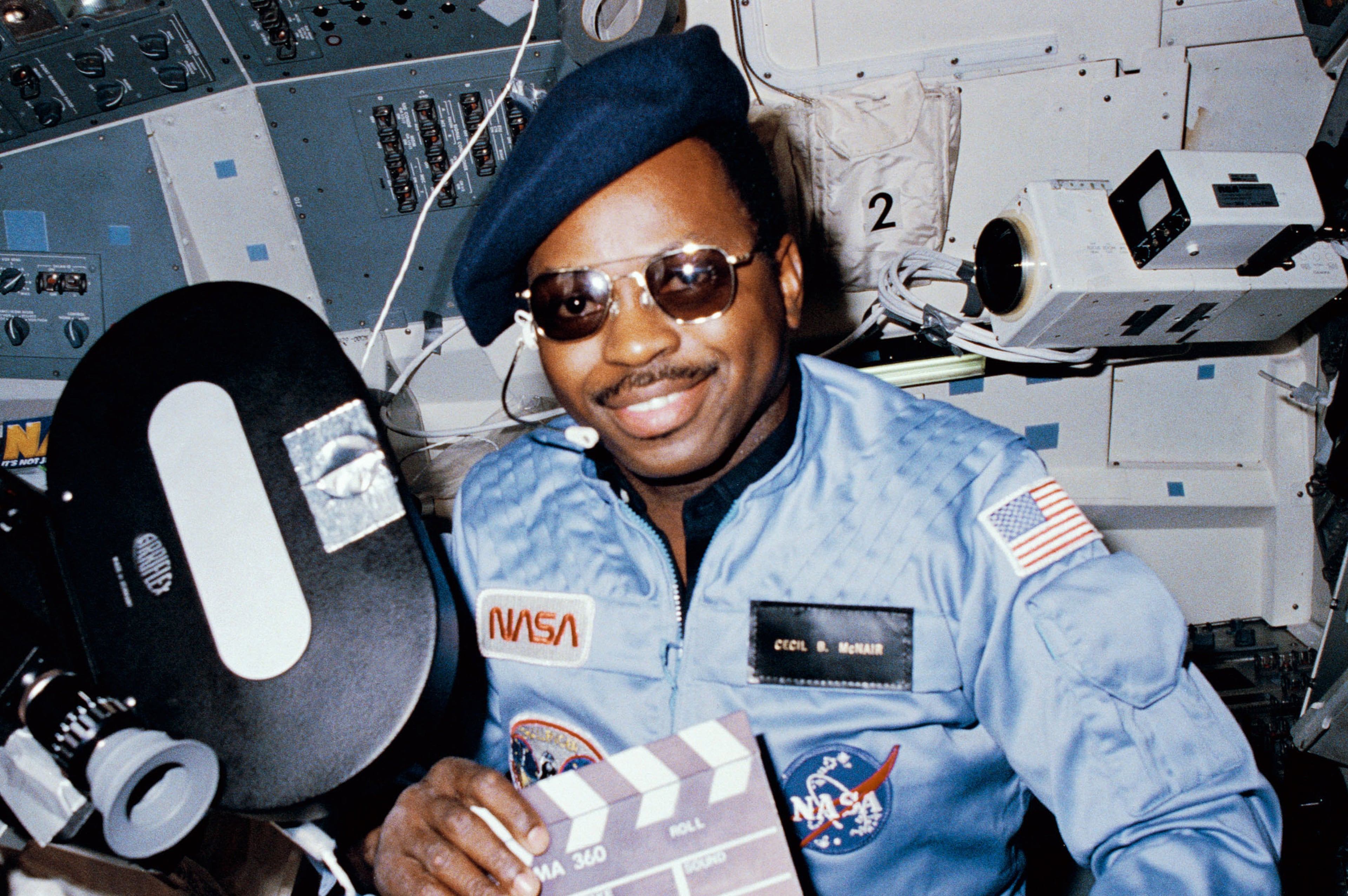 (3-11 Feb 1984) --- Astronaut Ronald E. McNair, 41-B mission specialist, doubles as 'director' for a movie being 'produced' aboard the Earth-orbiting Space Shuttle Challenger. McNair’s name tag ('Cecil B. McNair') and beret and slate are all humorous pro