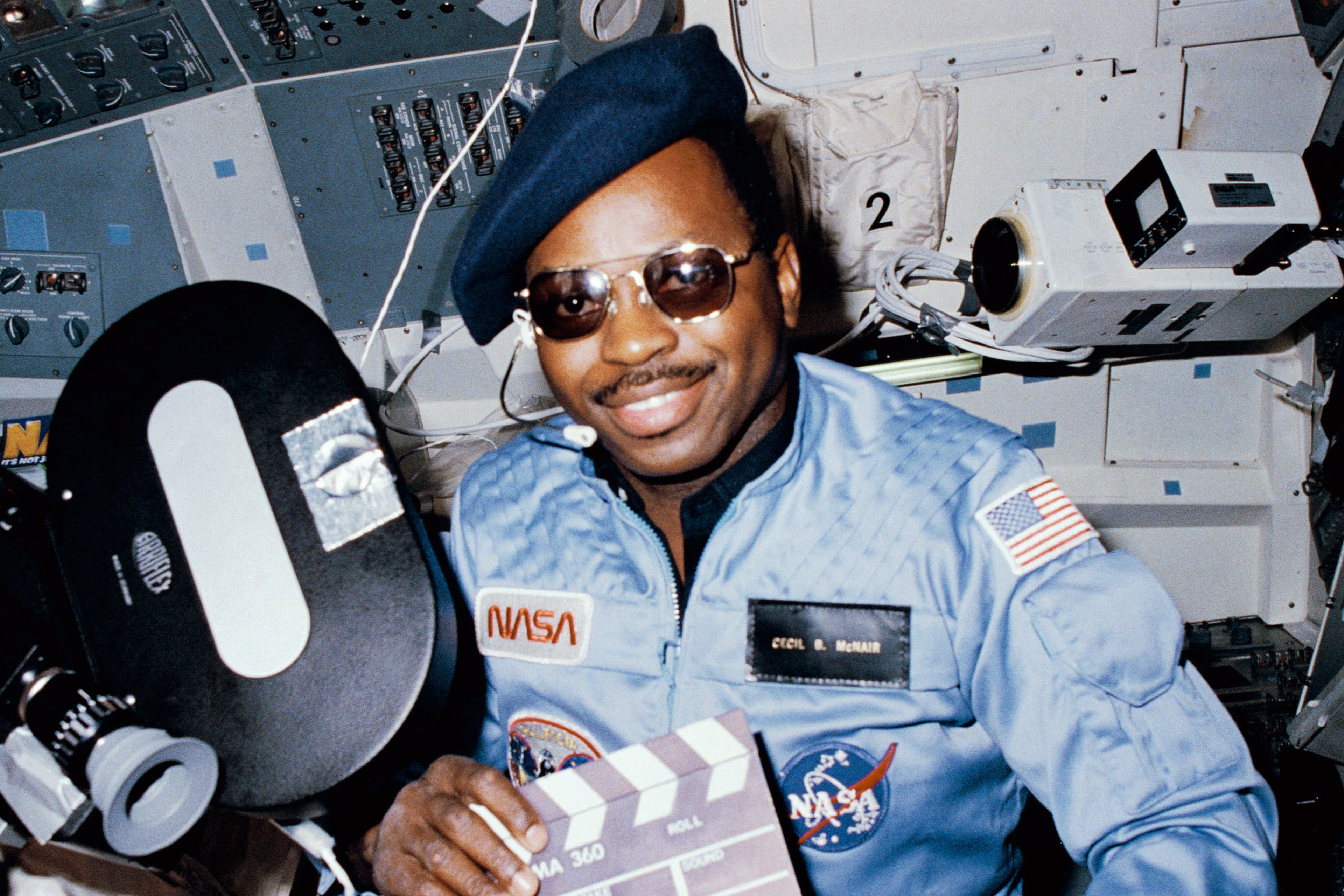 Astronaut Ronald McNair doubles as "director" for a movie being "produced" aboard the Earth-orbiting space shuttle Challenger in February 1984. McNair’s name tag ( "Cecil B. McNair"), beret and slate were all humorous props for application of a serious piece of cargo on the eight day flight: the Cinema 360 camera. In 1986, McNair was the mission specialist on the Challenger when it exploded 73 seconds after launch, killing all aboard. (HUM Images/Universal Images Group via Getty Images)