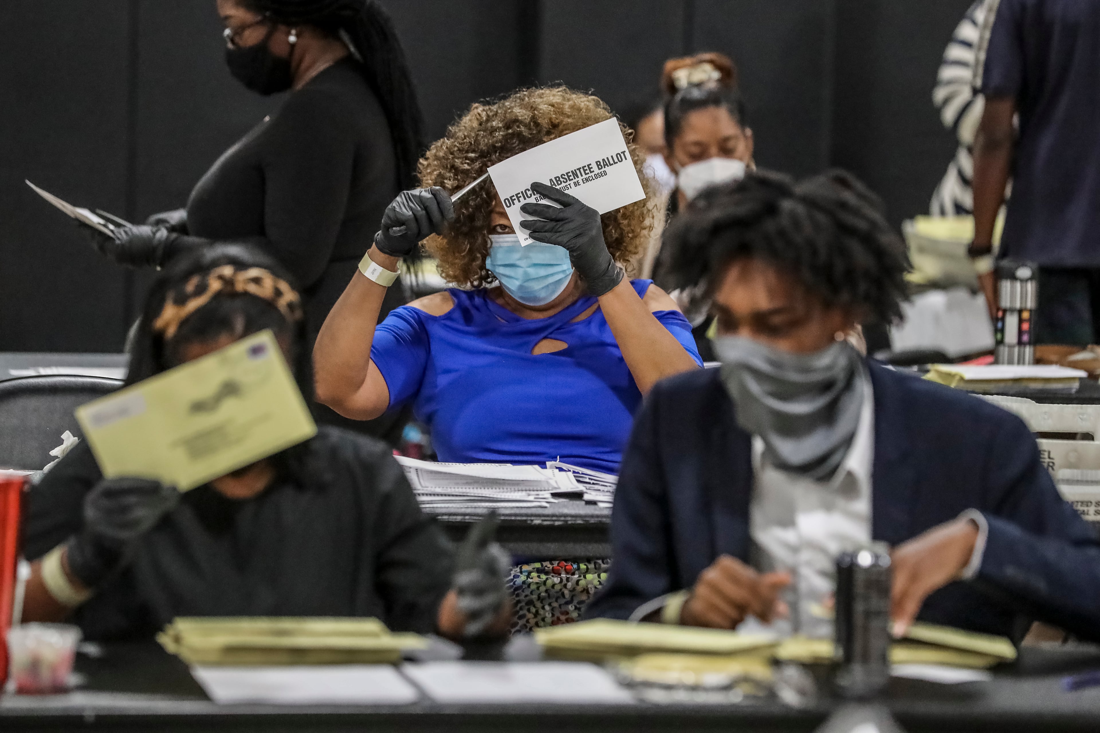 Fulton County Registration & Elections Board workers handle absentee ballots in August 2020. Two lawyers who represented Georgia Republicans in election cases are now working for the U.S. Department of Justice and have filed lawsuits to obtain Fulton's 2020 election records and Georgia's unredacted voter rolls. (John Spink/AJC 2020)