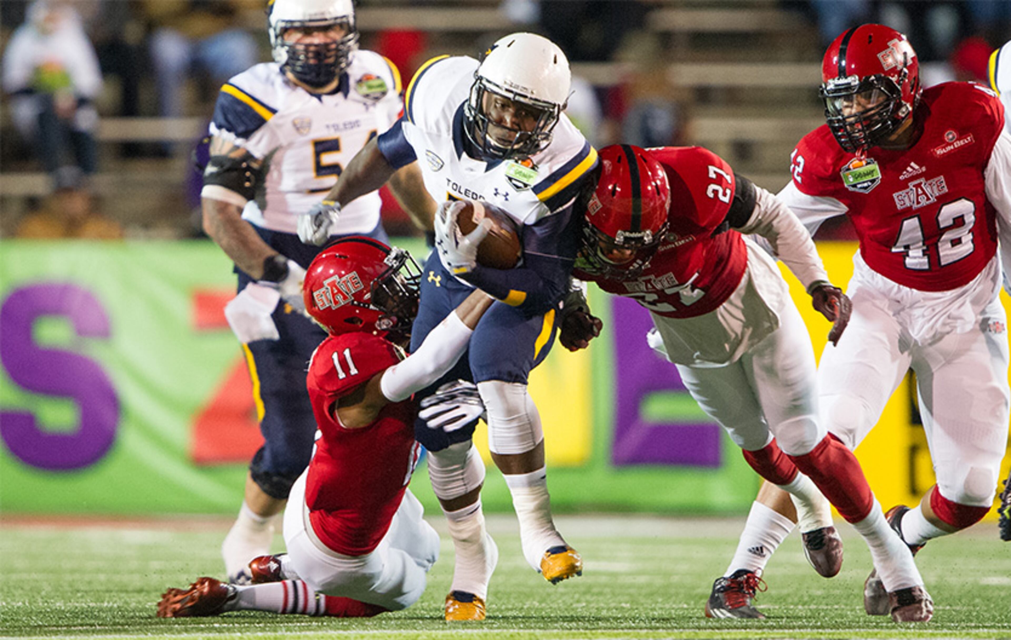 GoDaddy.com Bowl: Rockets running back Kareem Hunt rushed for a bowl-record 271 yards while scoring five rushing touchdowns - which tied him with former Oklahoma State running back Barry Sanders for most ever in a bowl game - leading Toledo to a 63-44 victory over Arkansas State. The offenses rolled up a combined 1,004 yards and 107 points, including a bowl-record 52 combined points in the first quarter alone in Mobile.