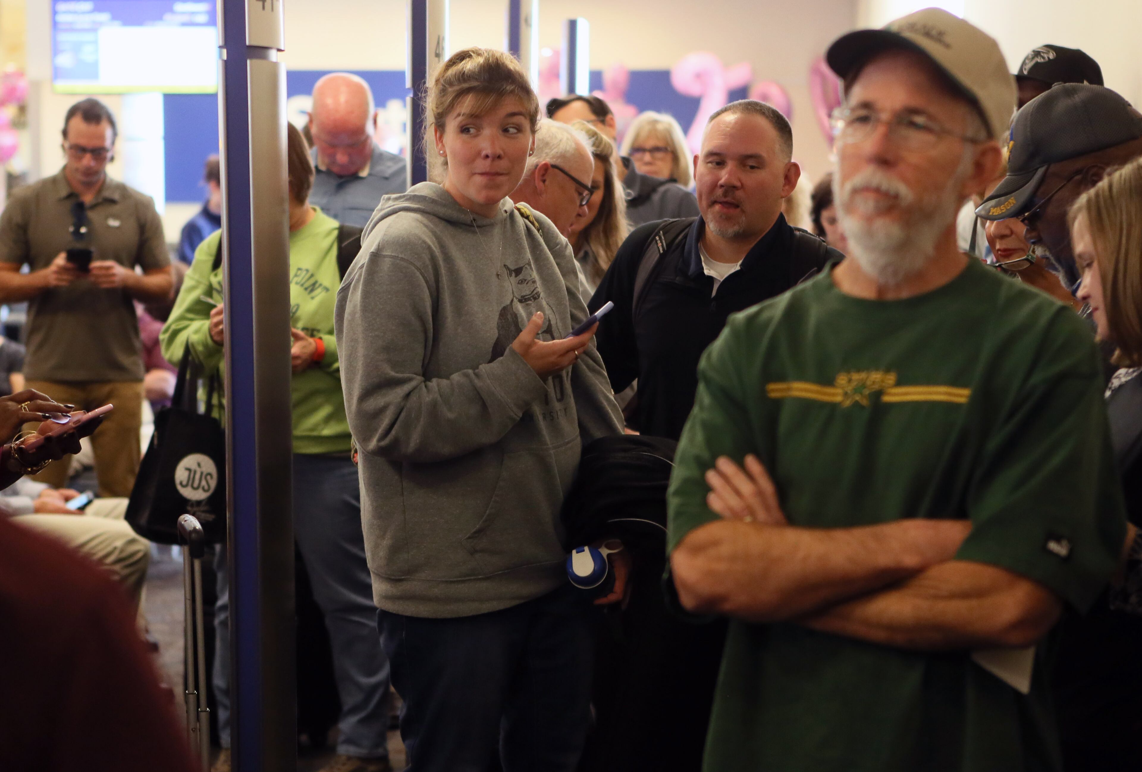 October 25, 2016 - Atlanta - Queued passengers watch as the Falcons make announcements and hand out luggage tags. Atlanta Falcons players and cheerleaders surprised travelers today as they traded places with Southwest Airlines Employees. Surprised travelers had a chance to meet the Falcons as they helped make announcements and joined with employees in collecting boarding passes. BOB ANDRES /BANDRES@AJC.COM