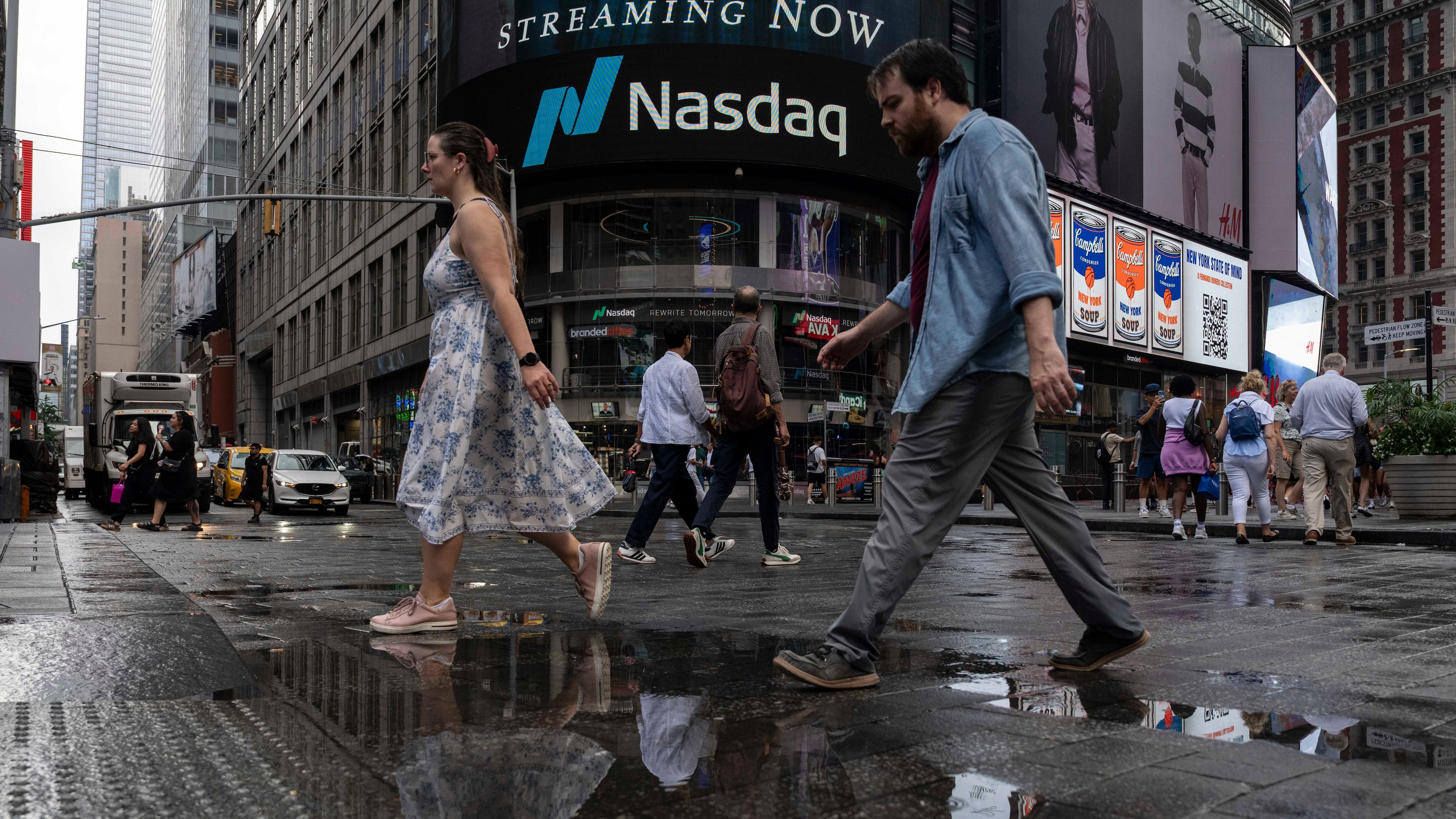 People walk past the Nasdaq MarketSite, Thursday, Aug. 6, 2026, in New York. (AP Photo/Yuki Iwamura)