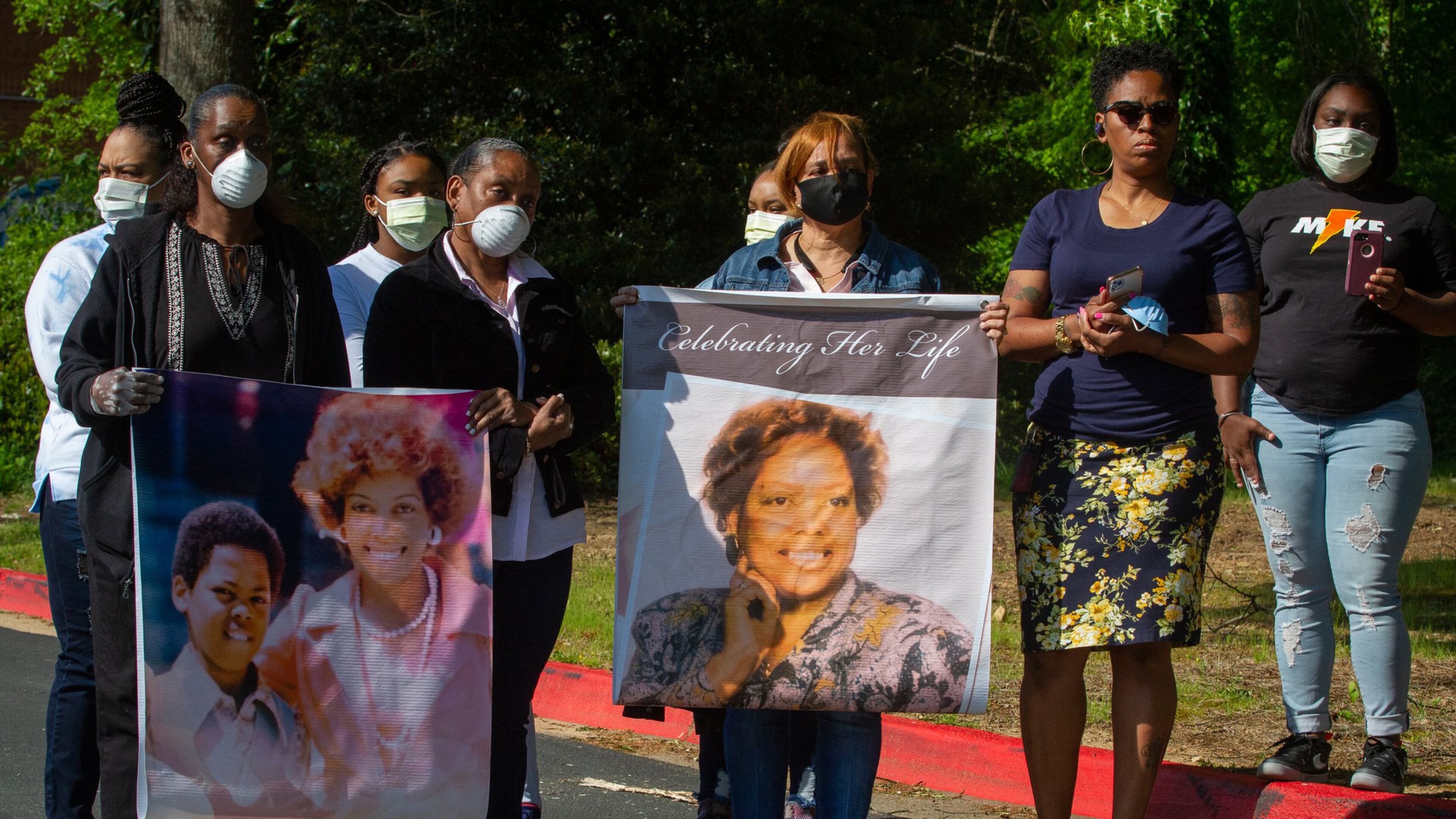 Family members hold photographs of Nancy Finney, who they say died of COVID-19 while living at Arbor Terrace at Cascade, an assisted living community in Fulton County. They attended a press conference near the facility Friday to call attention to the outbreak at the home and to urge that more be done. STEVE SCHAEFER / SPECIAL TO THE AJC