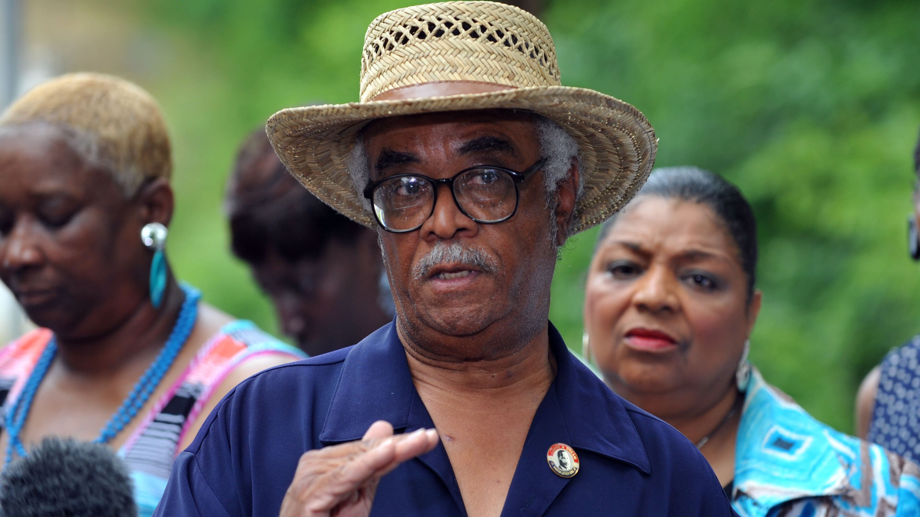 Supporters of Rep. Tyrone Brooks, D-Atlanta, listen as he holds a press conference at the Moore's Ford Bridge Thursday, May 30, 2013. The location of the news conference would appear to reflect supporters' beliefs that federal authorities are targeting Brooks as retaliation for his work to shine light on the unsolved 1946 lynching of two black couples along the bridge. Brooks has said he believes FBI agents at the time were involved.