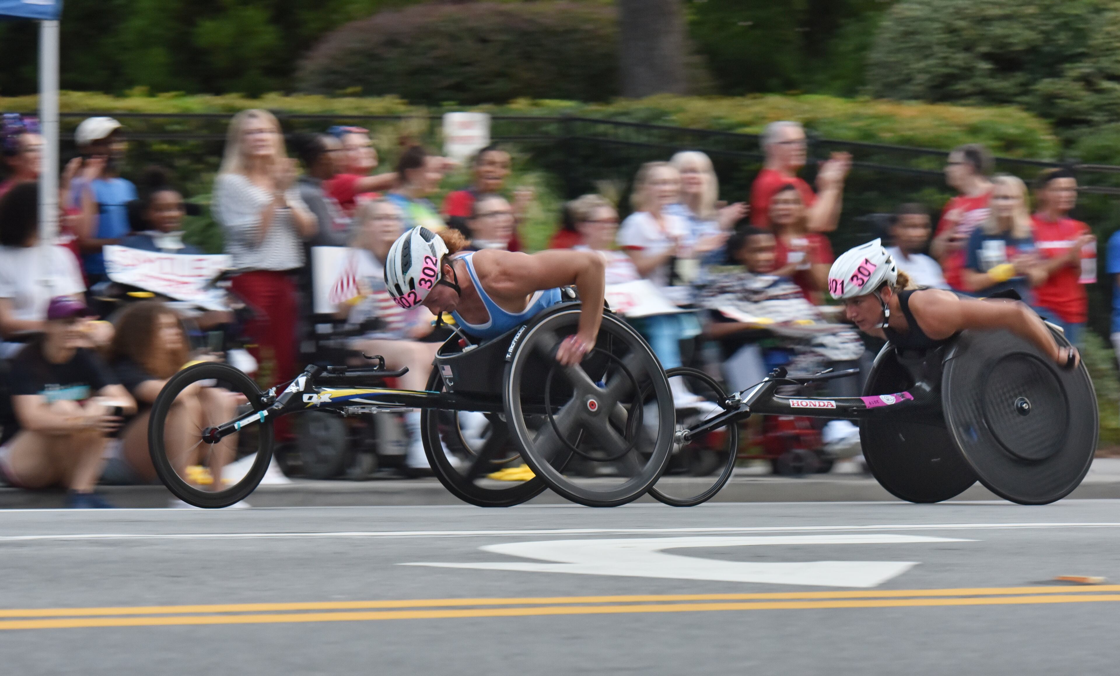 Wheelchair athletic Manuela Schar (right) tackles Cardiac Hill during the 50th AJC Peachtree Road Race on Thursday, July 4, 2019. (Hyosub Shin / Hyosub.Shin@ajc.com)