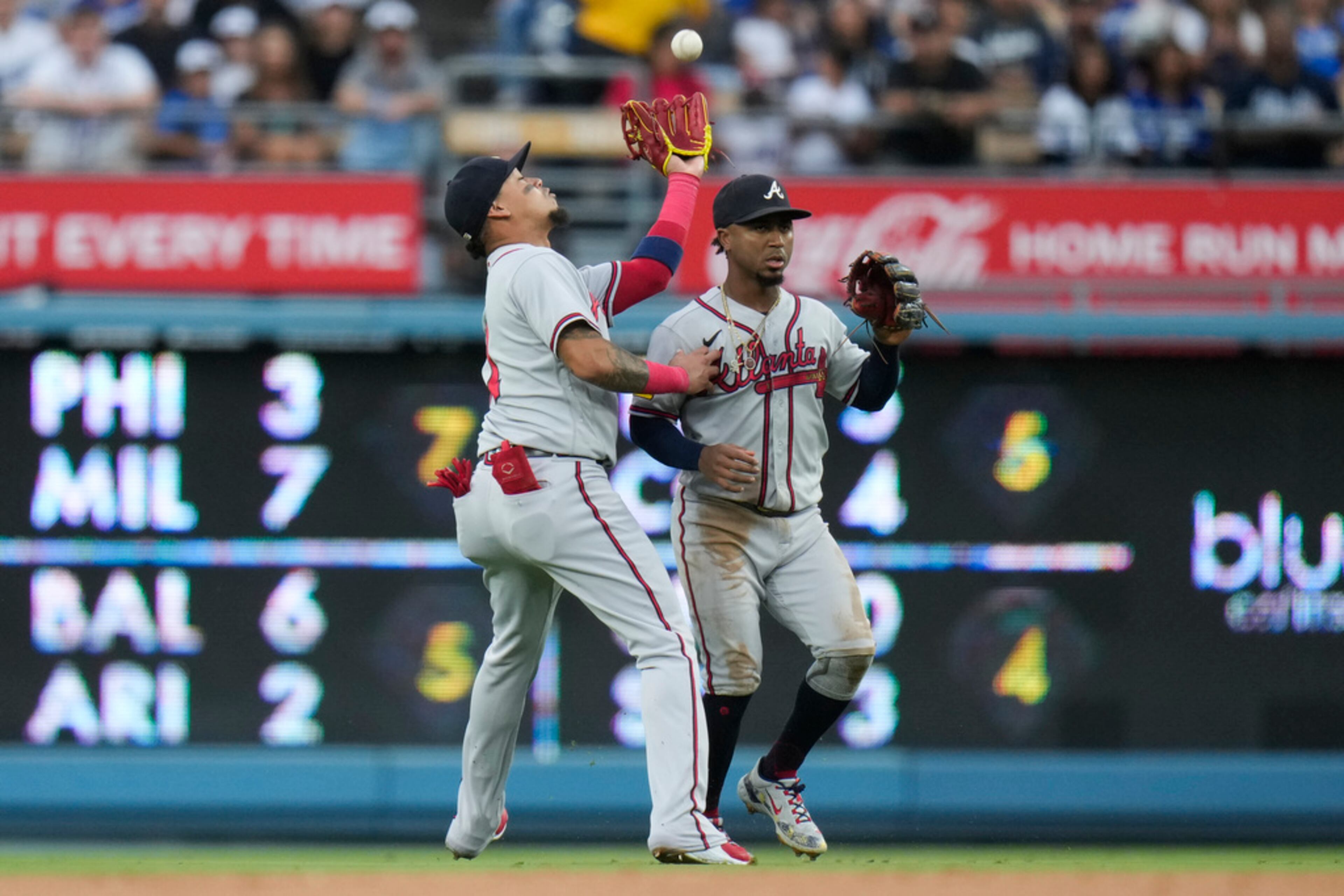 Atlanta Braves shortstop Orlando Arcia, left, catches a fly ball hit by Los Angeles Dodgers' James Outman, next to second baseman Ozzie Albies during the second inning of a baseball game Saturday, Sept. 2, 2023, in Los Angeles. (AP Photo/Jae C. Hong)