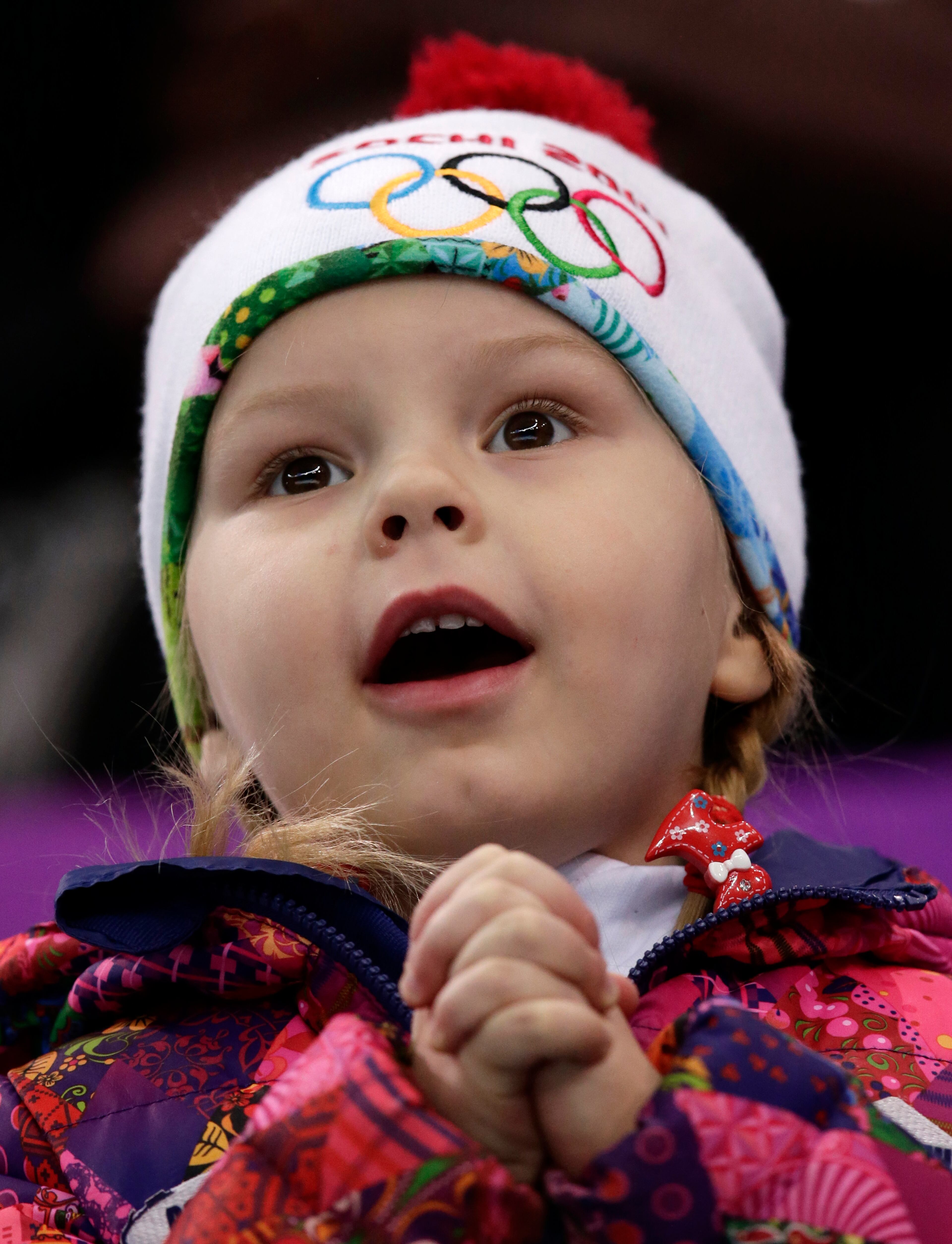 A young spectator waits for the start of the men's team free skate figure skating competition at the Iceberg Skating Palace during the 2014 Winter Olympics, Sunday, Feb. 9, 2014, in Sochi, Russia. (AP Photo/Bernat Armangue)