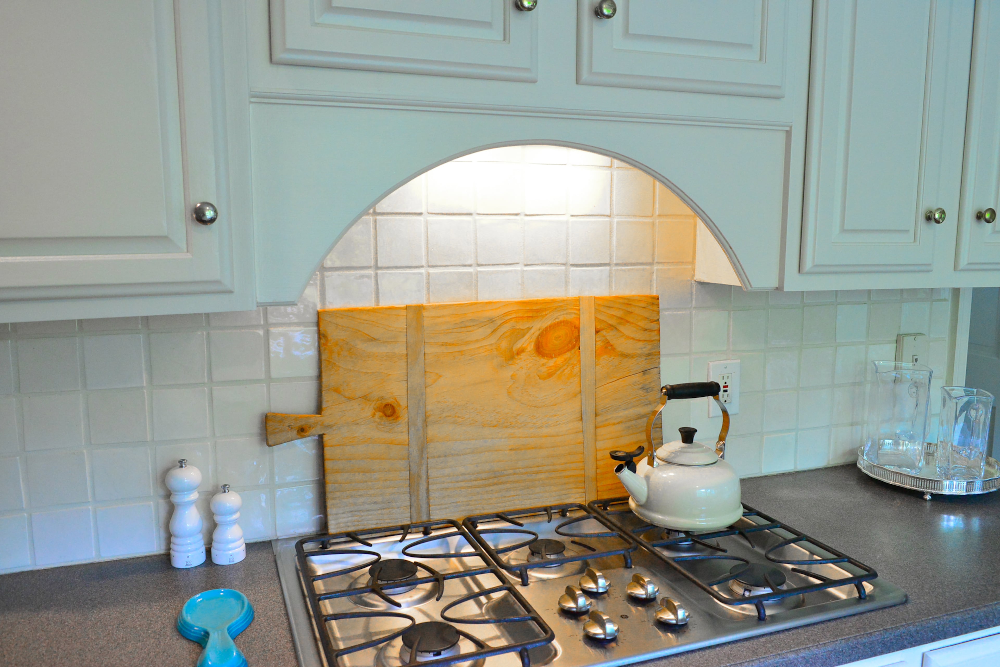 GE appliances, including a gas range, are set amid white cabinets and white tile backsplash in the kitchen.
