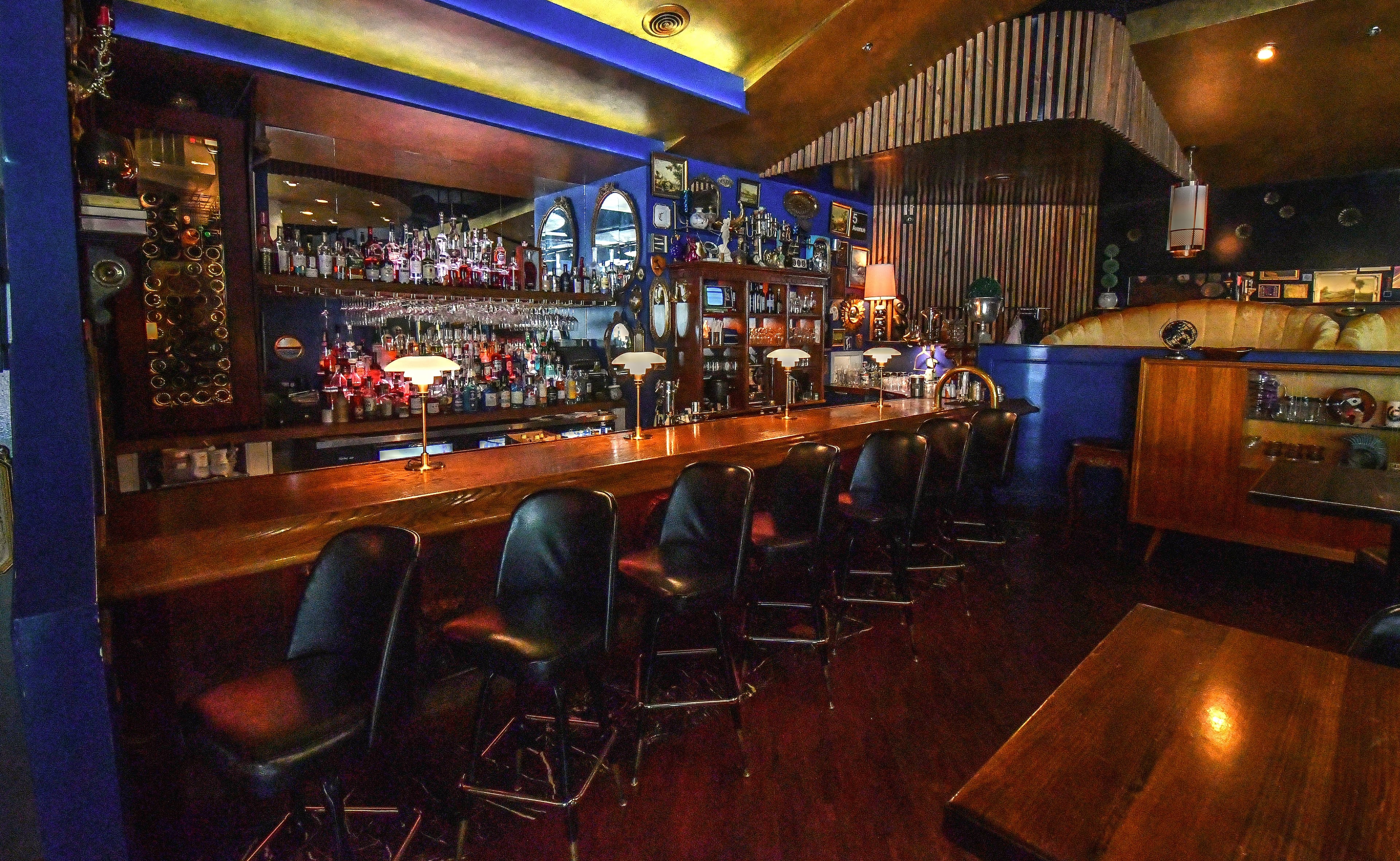 Douglas Hines, co-owner and interior designer of the Consulate, said people will sometimes try to purchase furniture or decorative elements from the restaurant, requests that he always declines. A 1950s glass cabinet near the bar is one of the most requested items, Hines said. (Chris Hunt for The Atlanta Journal-Constitution)