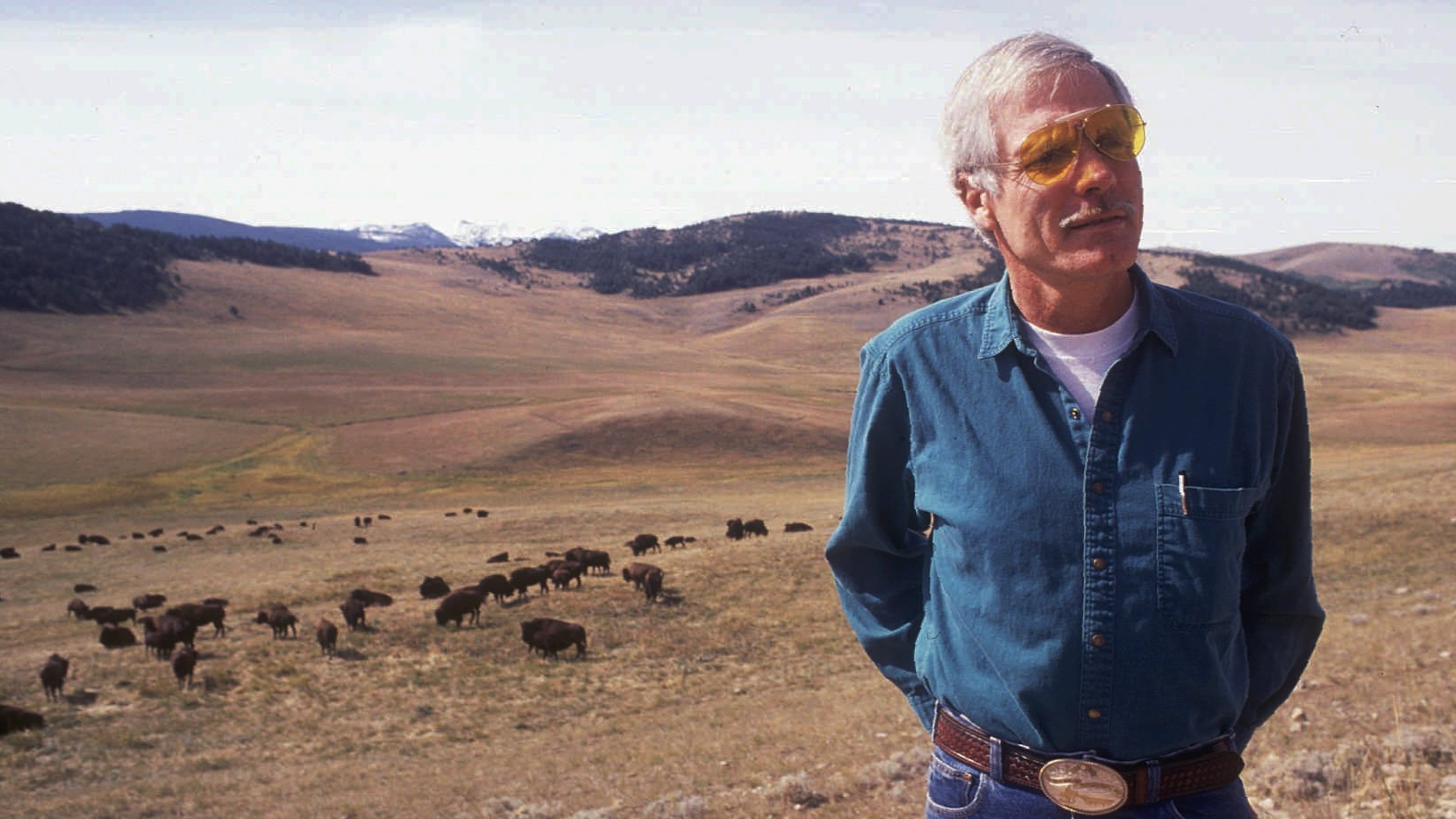 Ted Turner stands near a herd of his bison in this September 1991 file photo at his 107,000-acre Flying D Ranch near Bozeman, Mont. After buying a few American buffalo two decades ago mainly just to look at on his Florida farm, Turner has developed his herd into the nation's largest with some 15,000 on ranches in Montana, Nebraska and New Mexico. (Linda Best/AP/Bozeman Daily Chronicle/File)
