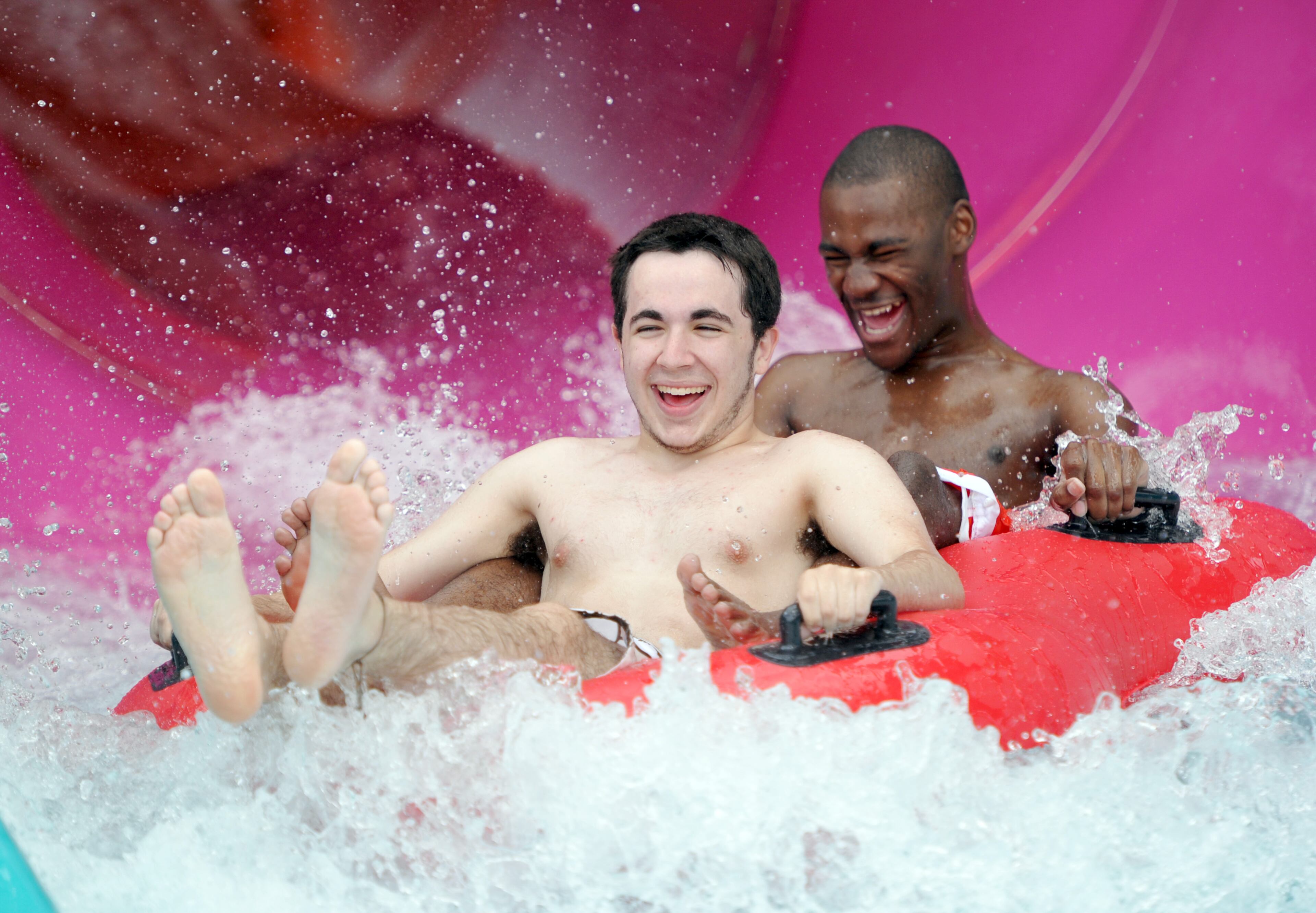 Matthew Prater (left) and Aaron Roberson enjoy riding Bonzai Pipelines during a media day at the Six Flags Hurricane Harbor water park Thursday, May 28, 2014. Three unique water slides sit atop a 41 foot tower at that propel guests barreling down through 180- and 360-degree curves. HYOSUB SHIN / HSHIN@AJC.COM