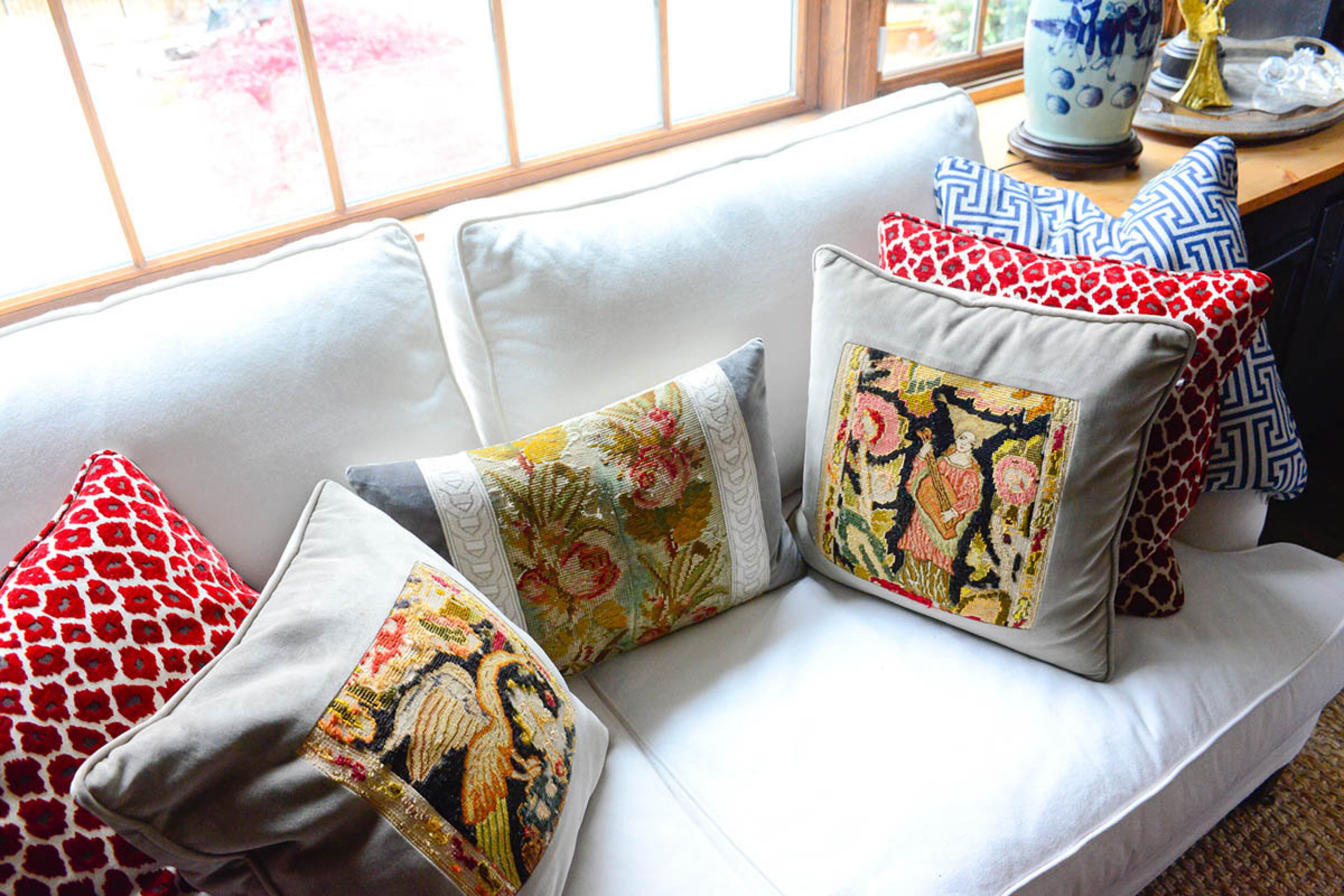 Kathy Hogan Trocheck's love of antique textiles and needlepoint is evident in her collection of pillows from estate sales. These add a vintage touch to a new couch from Stanton Home Furnishings.