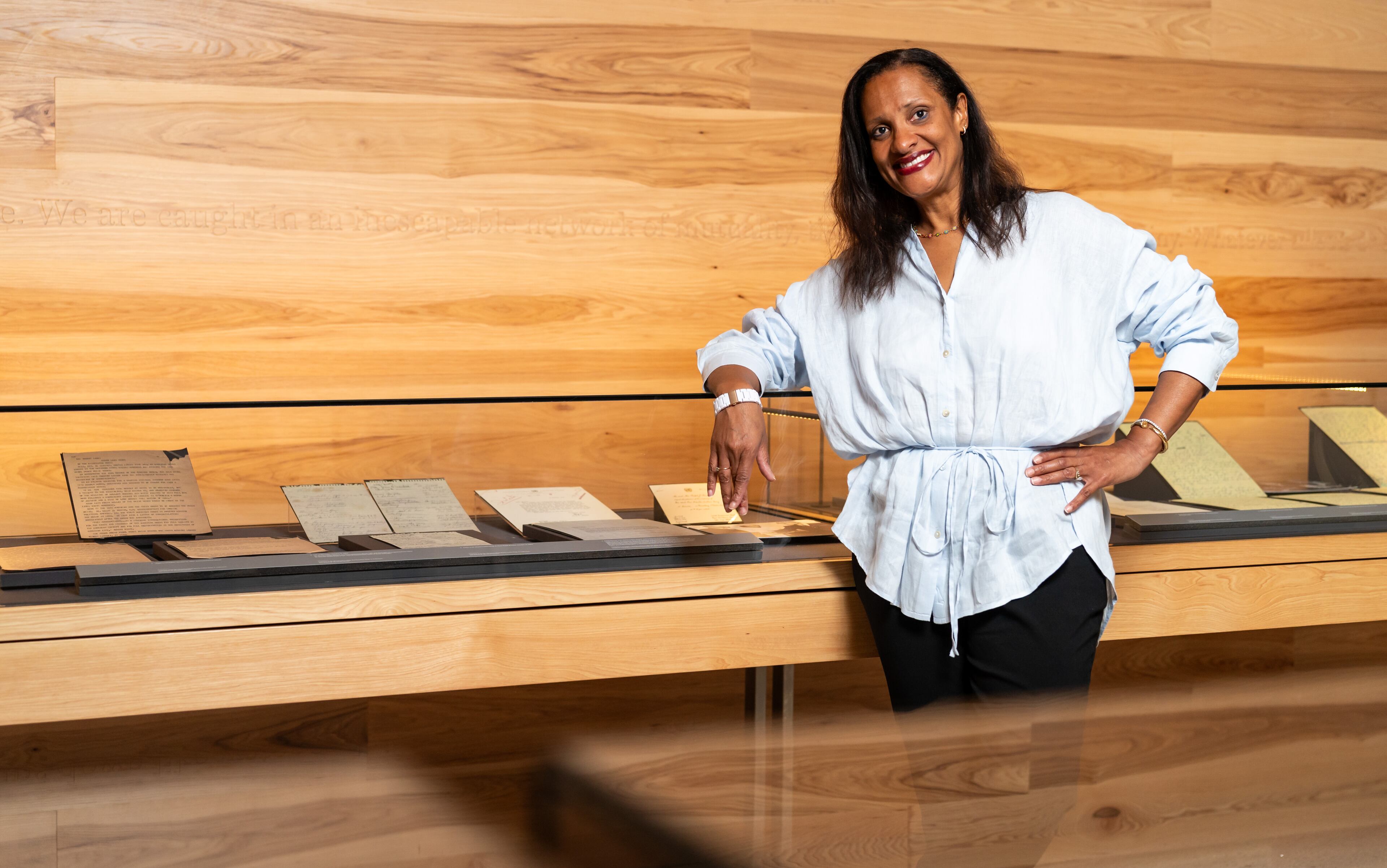 Chief Program Officer Kama Pierce poses with personal papers of Dr. Martin Luther King Jr. preserved in the Voice to the Voiceless Gallery at the National Center for Civil and Human Rights in Atlanta on Thursday, July 11, 2024. (Seeger Gray / AJC)