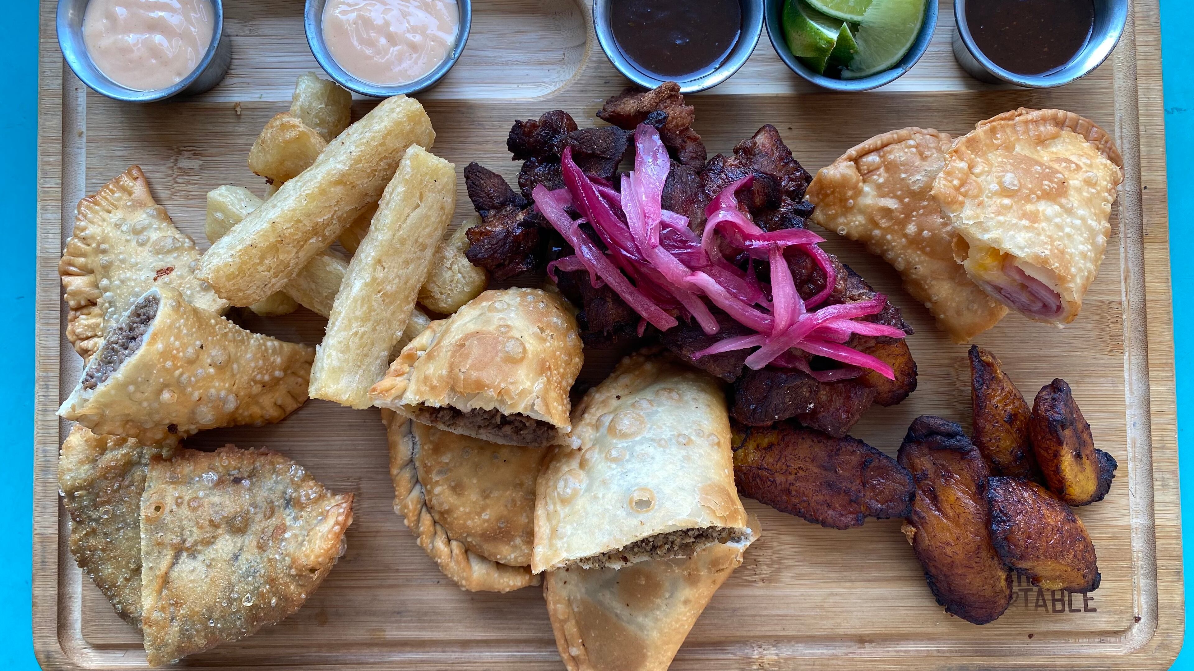 A tabla from Raul's Latin Kitchen brings a selection of Puerto Rican appetizers, including empanadas, carne frita and maduros. (Ligaya Figueras / ligaya.figueras@ajc.com)