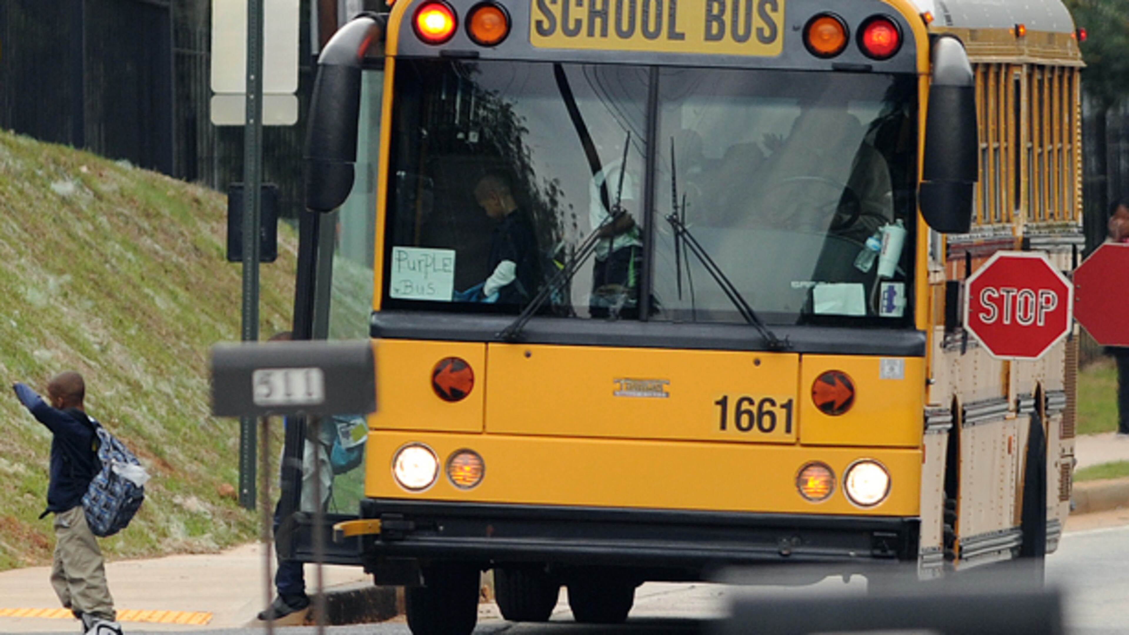 A Cobb County school bus stops on Six Flags Drive to let students off Oct. 8. Cobb County school buses are equipped with a cellphone GPS system. Complaints are down and more kids are being picked up on time thanks to the system the county purchased a little more than a year ago, according to administrators.