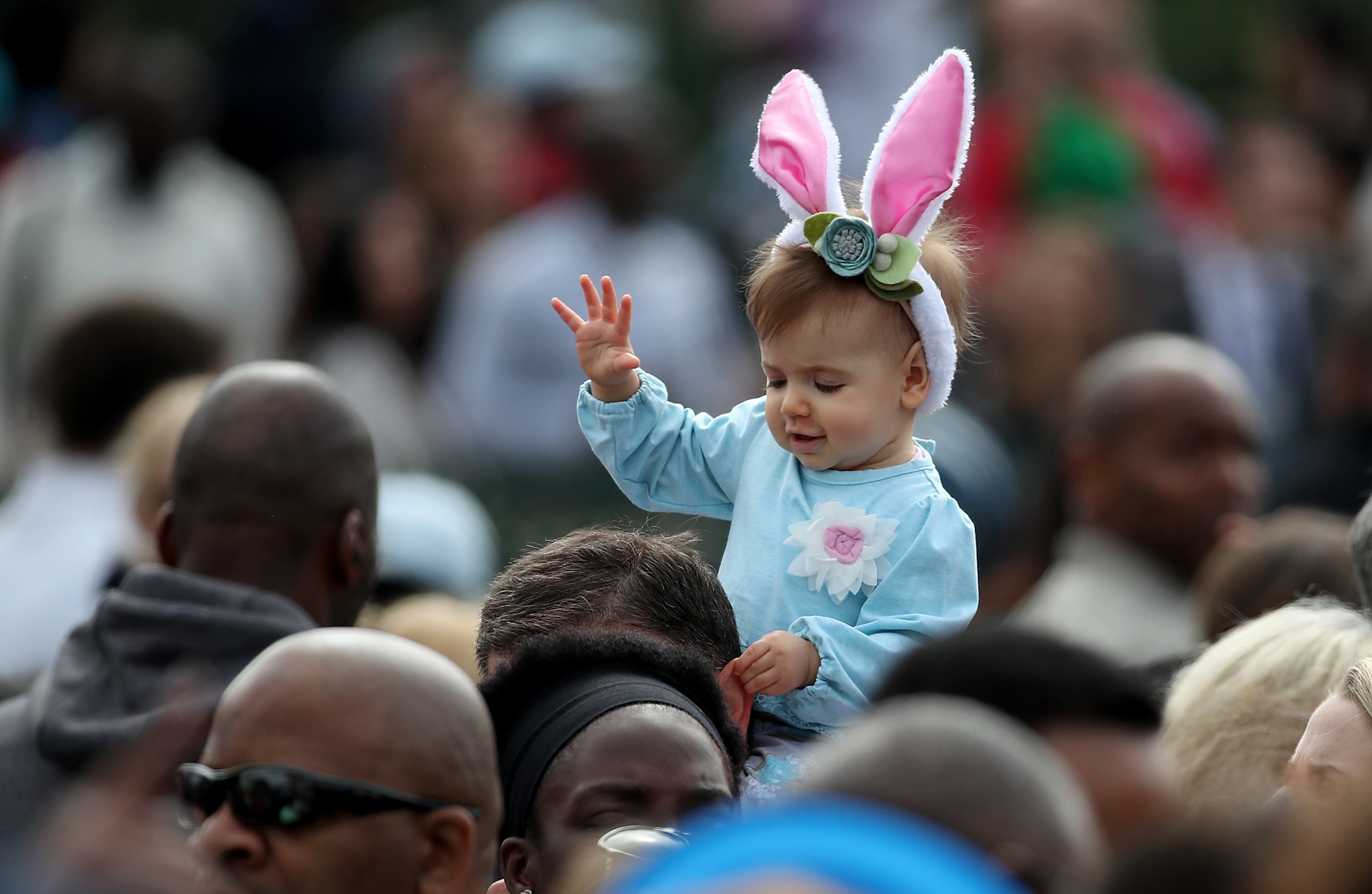 WASHINGTON, DC - MARCH 28: A young girls rides on her father's shoulders on the South Lawn of the White House during the annual White House Easter Egg Roll March 28, 2016 in Washington, DC. Thousands of people attended the 138-year-old tradition of rolling colored eggs down the White House lawn that was started by President Rutherford B. Hayes in 1878. (Photo by Win McNamee/Getty Images)