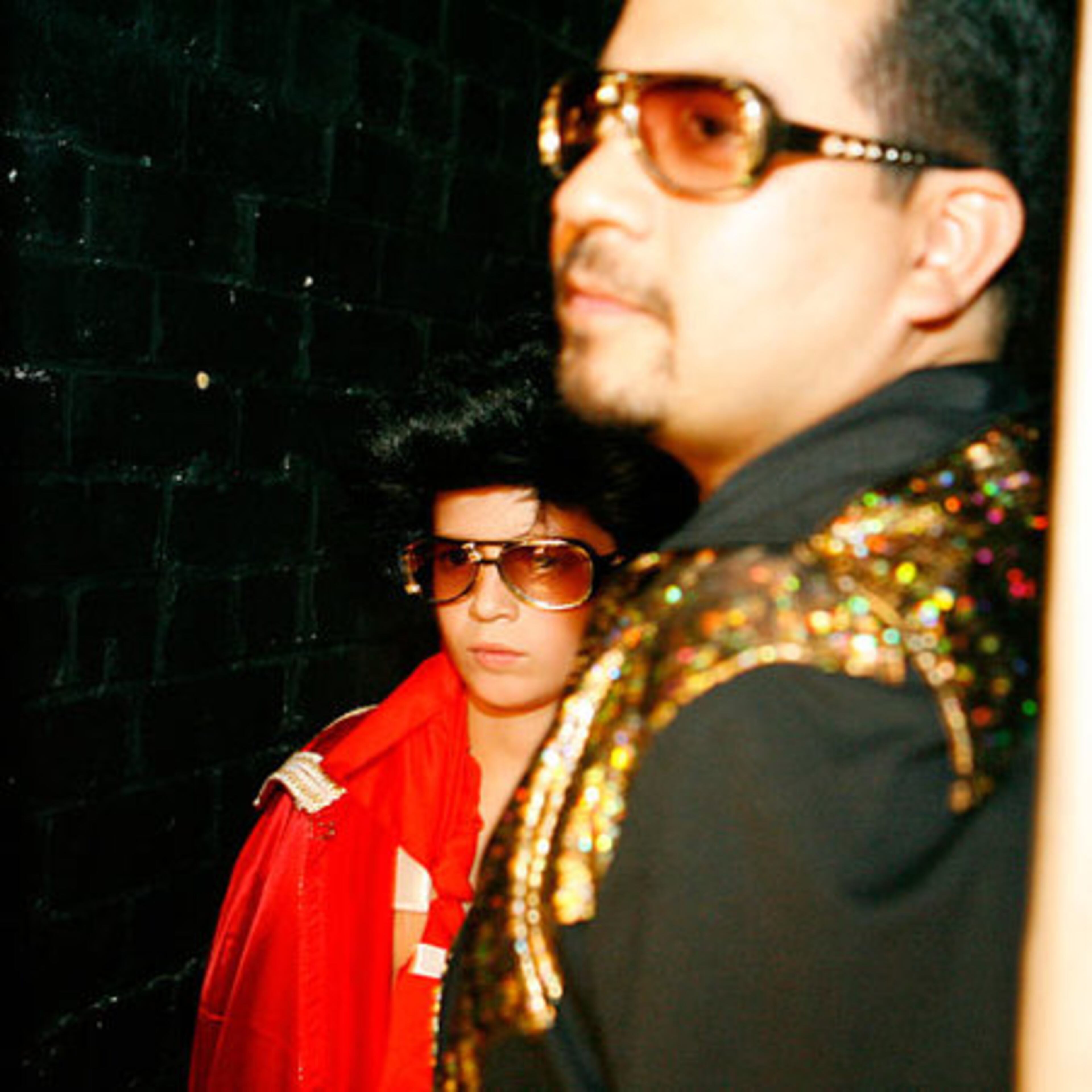 Sunglasses at night: Elijah Maris (left), 11, and Miguel Trivino wait to go onstage with other Elvis-dressed audience members during one of the final numbers in the Elvis Royale show.