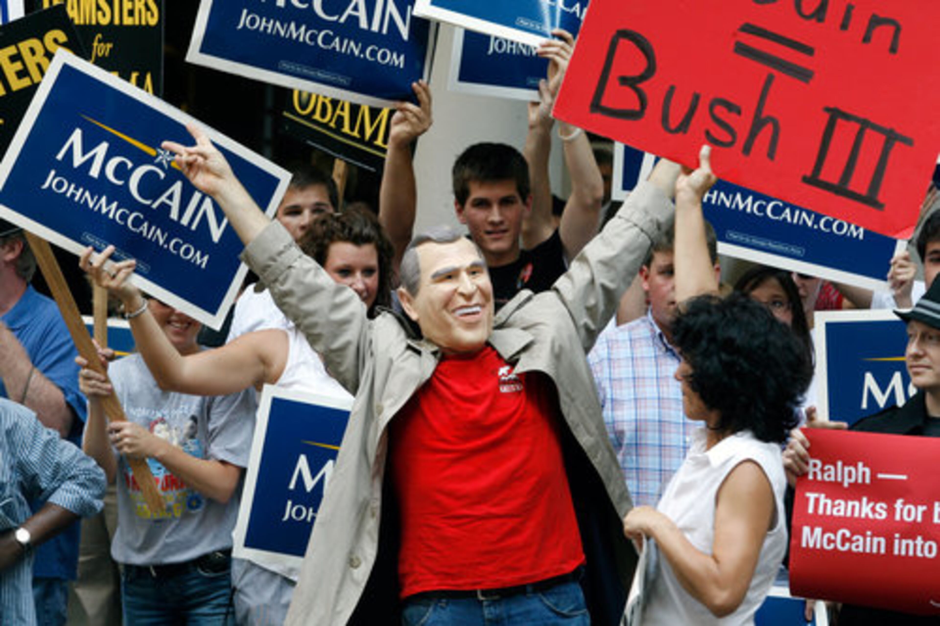 Thaddeus Stephens wears a George Bush mask as he protests against John McCain in front of a group of McCain supporters at the Marriott Marquis.