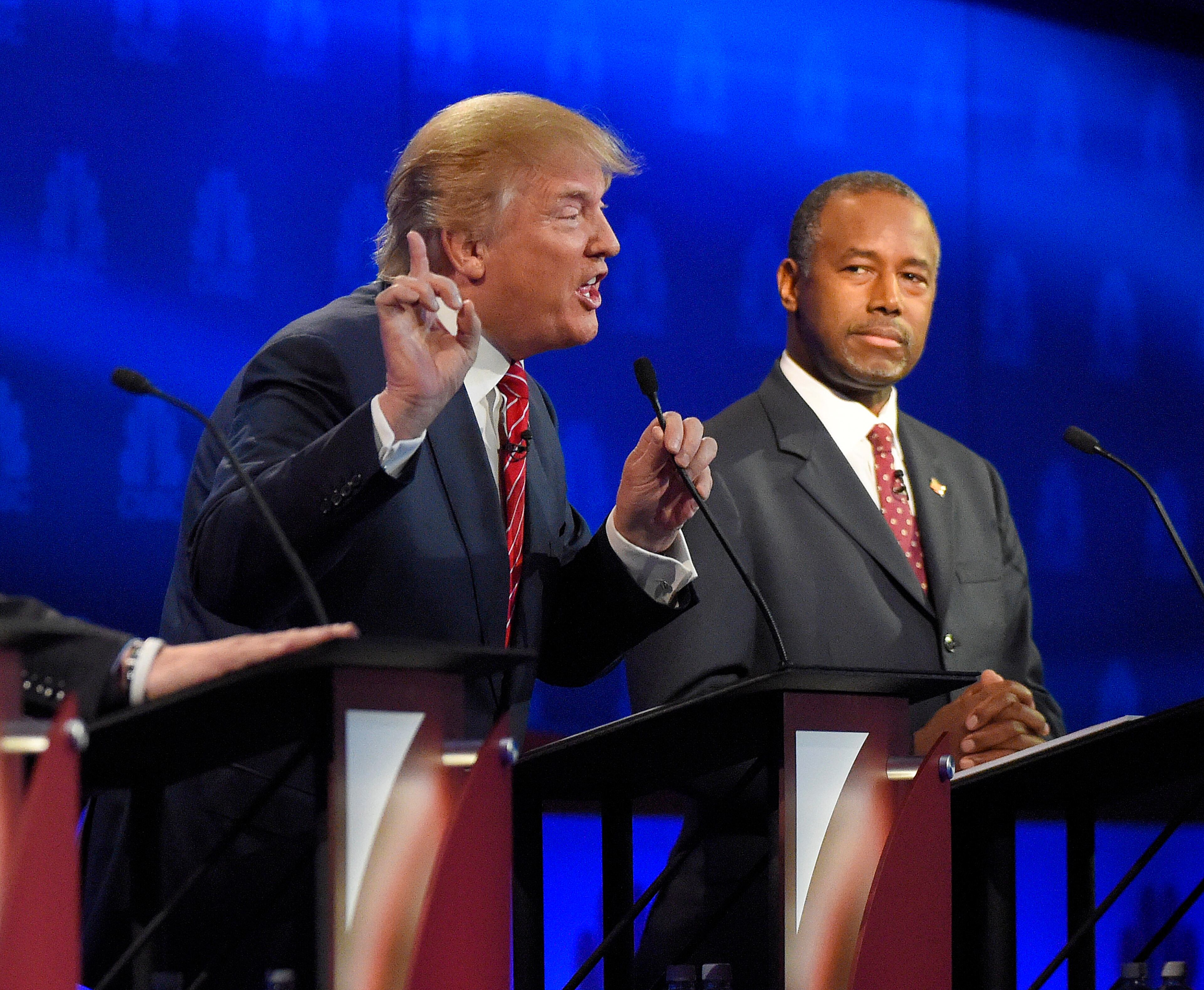 Ben Carson, right, watches as Donald Trump speaks during the CNBC Republican presidential debate at the University of Colorado, Wednesday, Oct. 28, 2015, in Boulder, Colo. (AP Photo/Mark J. Terrill)