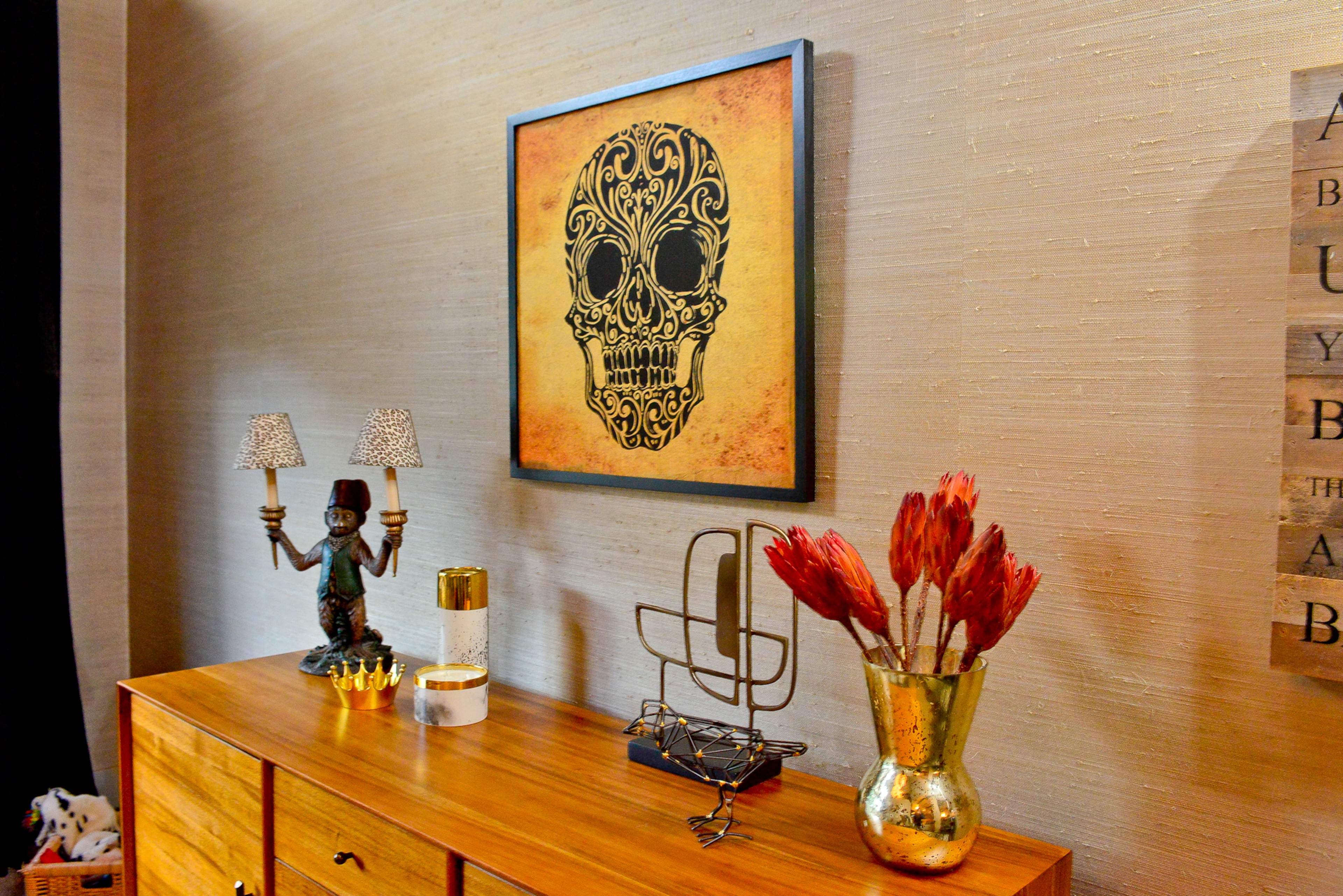 Inside the house, quirky artwork includes a skull canvas framed print from Pottery Barn atop the Mid-Century Console from West Elm, both of which the homeowners purchased after they moved in.