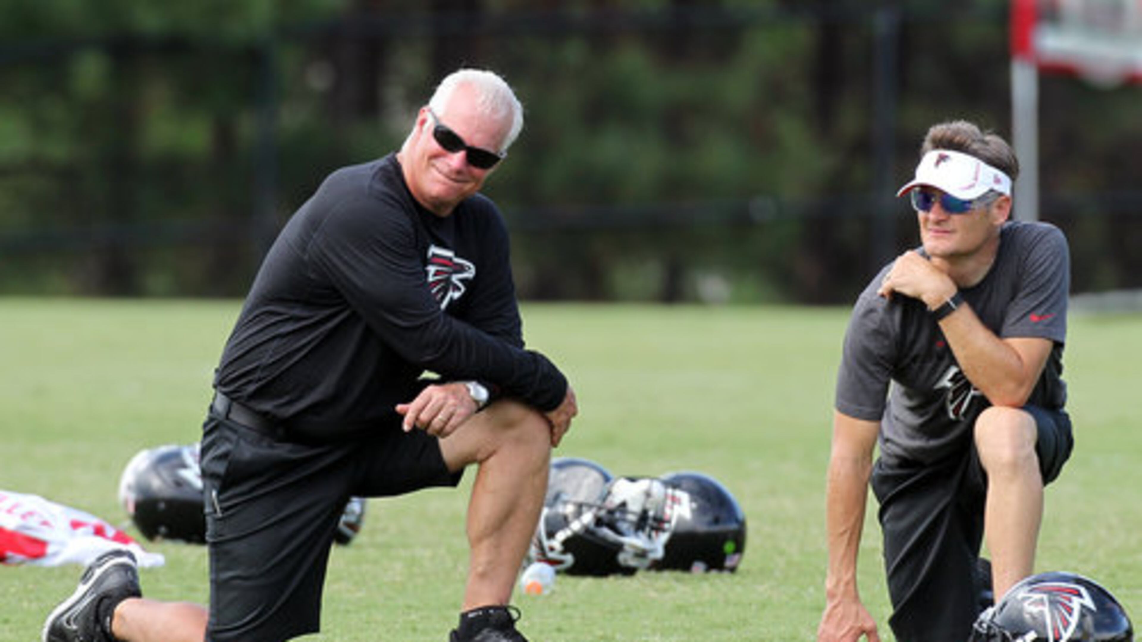 Head coach Mike Smith (left) and general manager Thomas Dimitroff watch over practice in Flowery Branch on Friday, July 27, 2012.