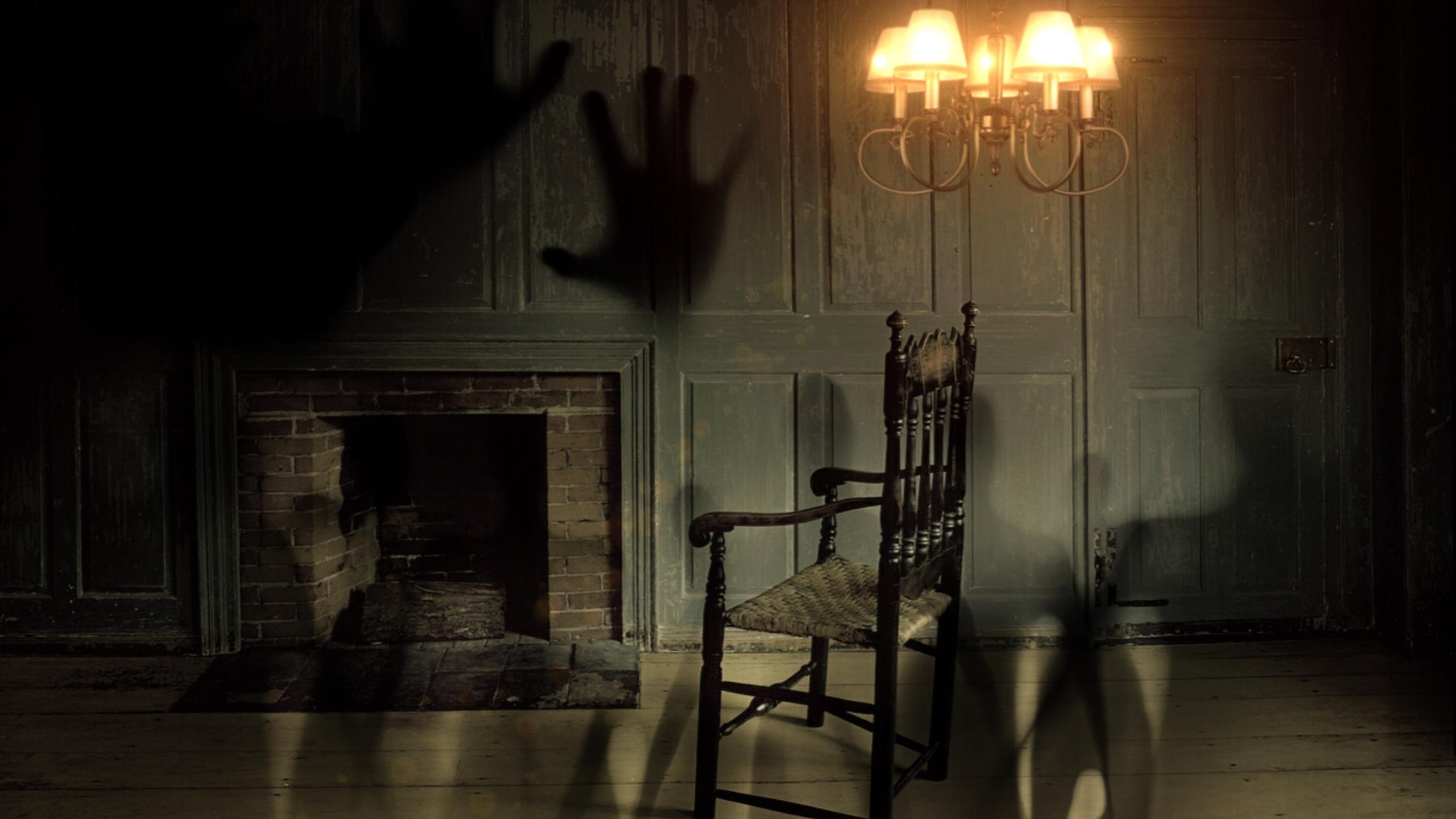 A spooky, dark room with shadows on the walls evokes a haunted feeling with the possibility of ghostly visitors.