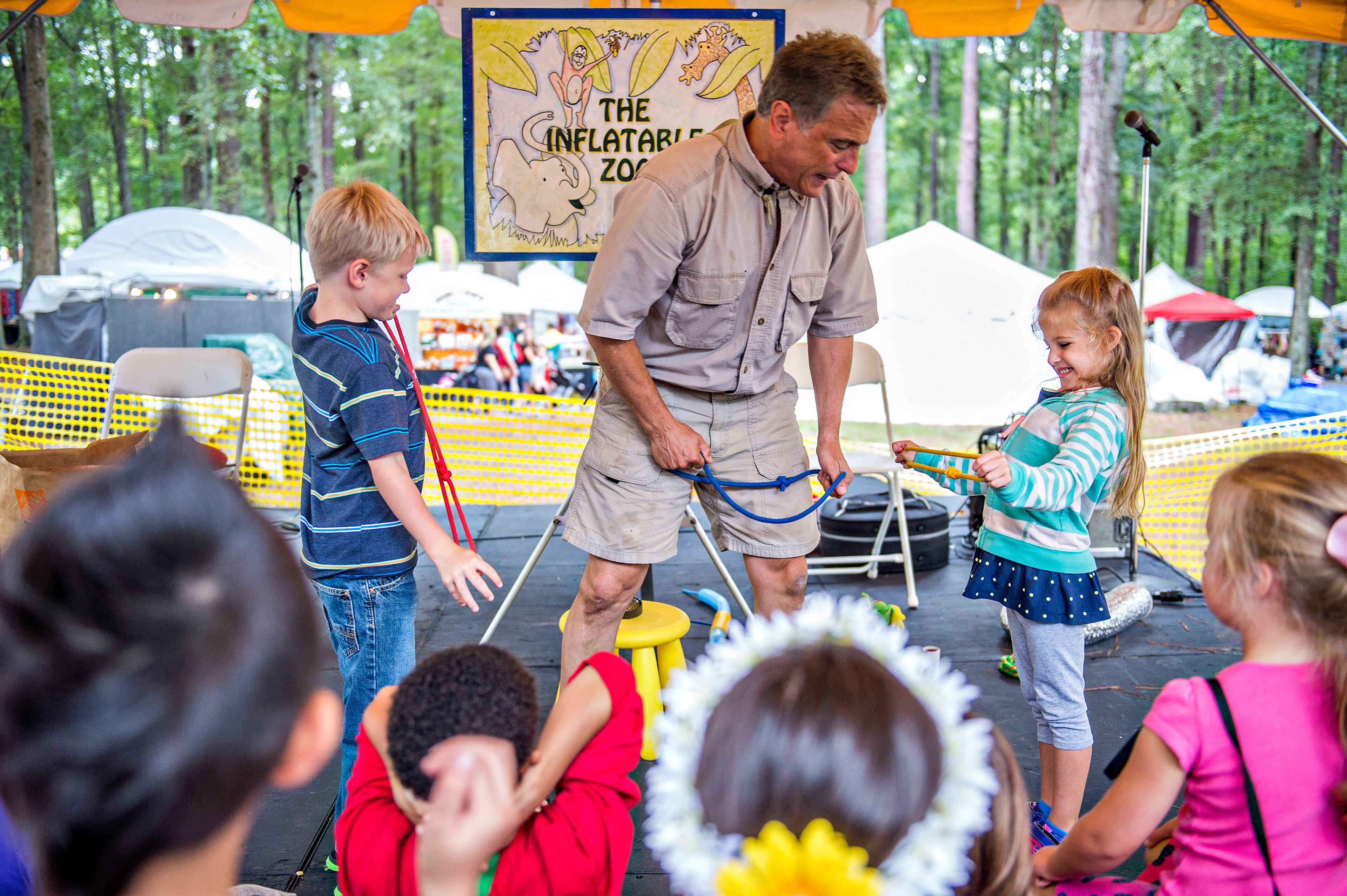 September 12, 2015 Stone Mountain - Adam Komesar (center) gets help from Pierce Lawson (left) and Haley Carpenter as he entertains children during the Yellow Daisy Festival at Stone Mountain Park on Saturday, September 12, 2015. In its 47th year, the festival features more than 400 artists from all over the country over four days. JONATHAN PHILLIPS / SPECIAL