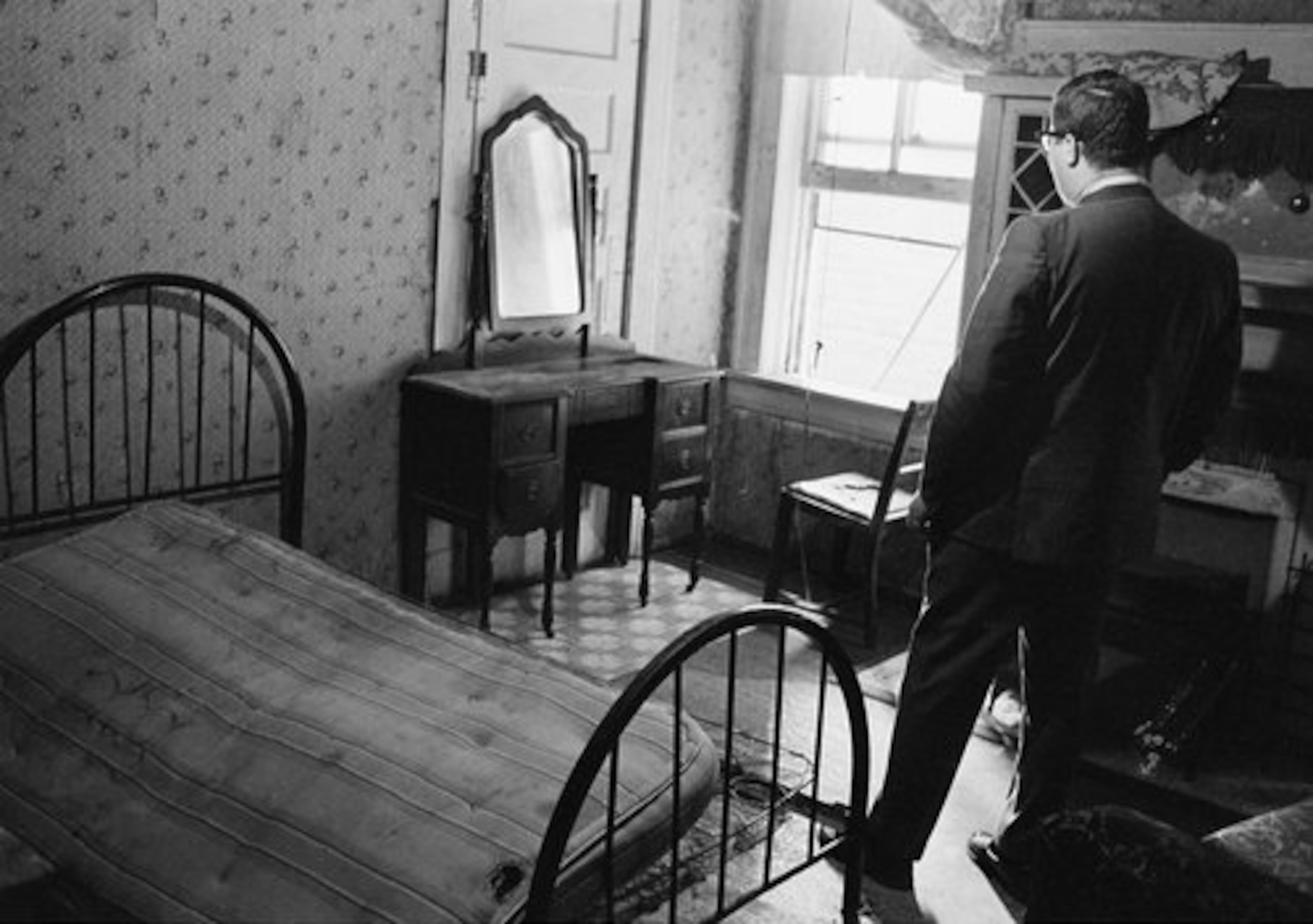 A news reporter stands in the room rented by the assassin who shot Dr. Martin Luther King Jr., in Memphis, Tenn., April 5, 1968. From an adjacent bathroom window, the assassin shot and killed the civil rights leader who was standing on the balcony of the Lorraine Motel in Memphis, Tennessee on April 4.