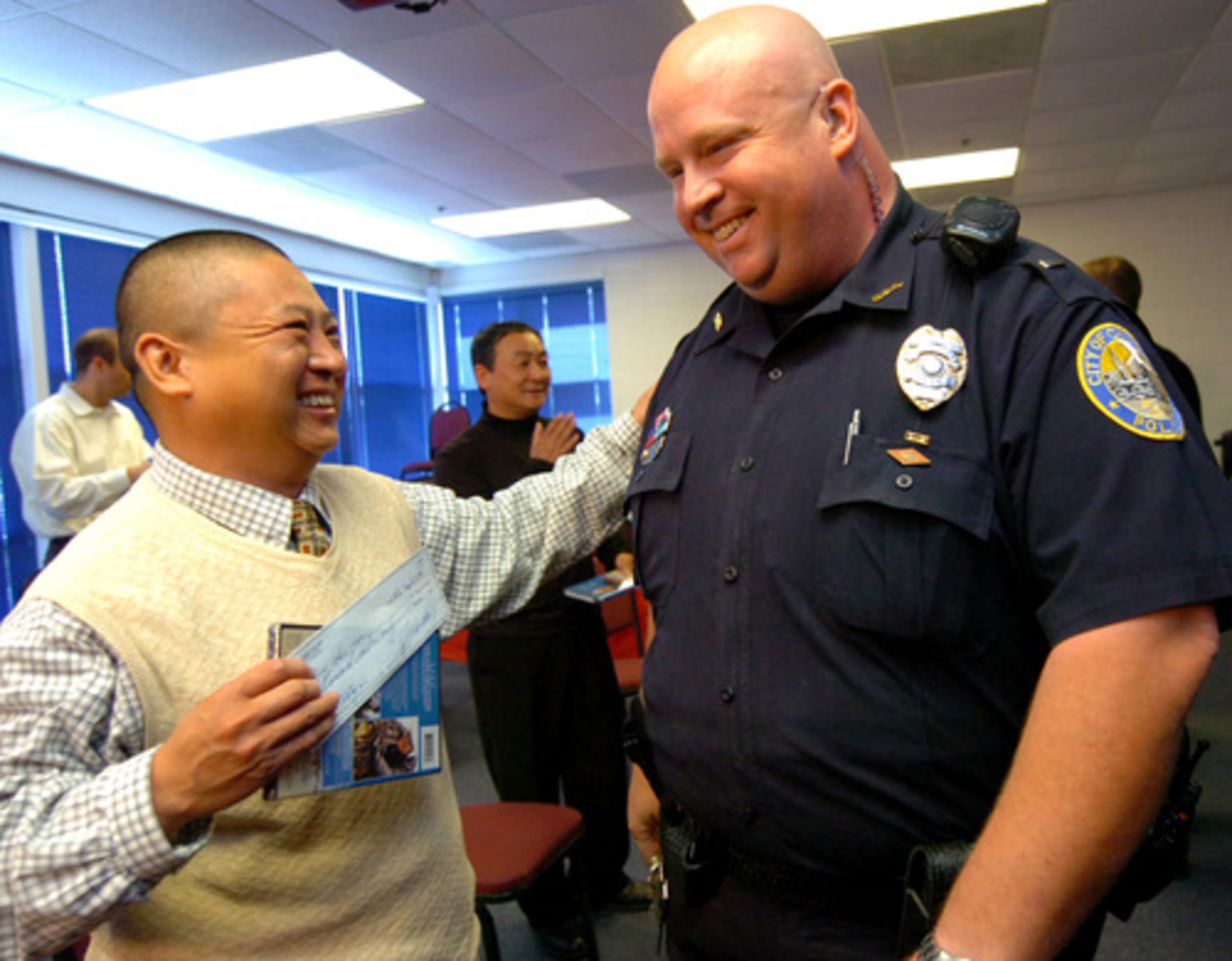 Gui Sen Wu talks with officer S. Harris (right) of Chamblee Police Department.