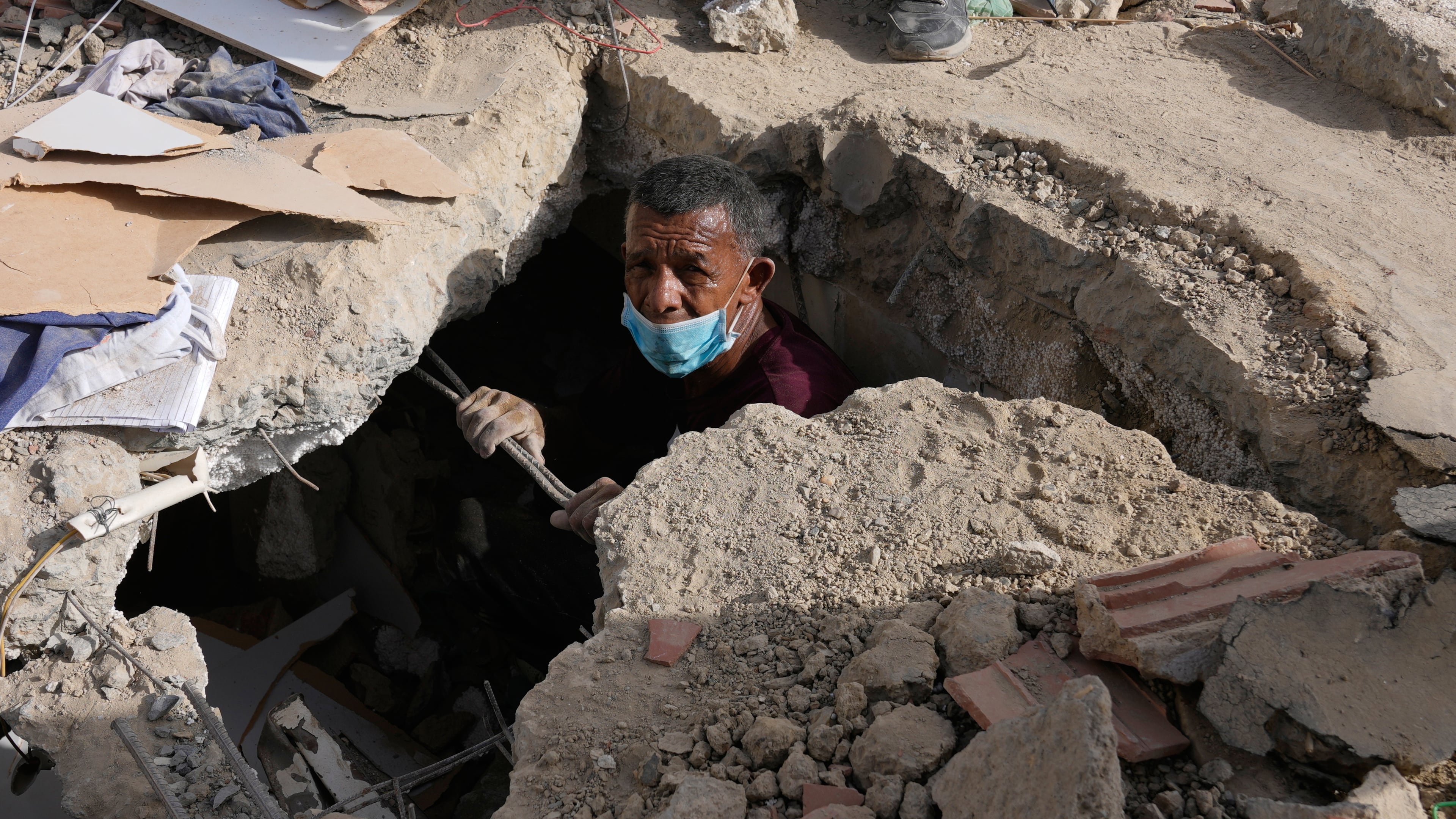 Franklin Fuentes searches for missing relatives in the collapsed building where they lived two days after earthquakes struck La Guaira, Venezuela, Friday, June 26, 2026. (AP Photo/Ariana Cubillos)