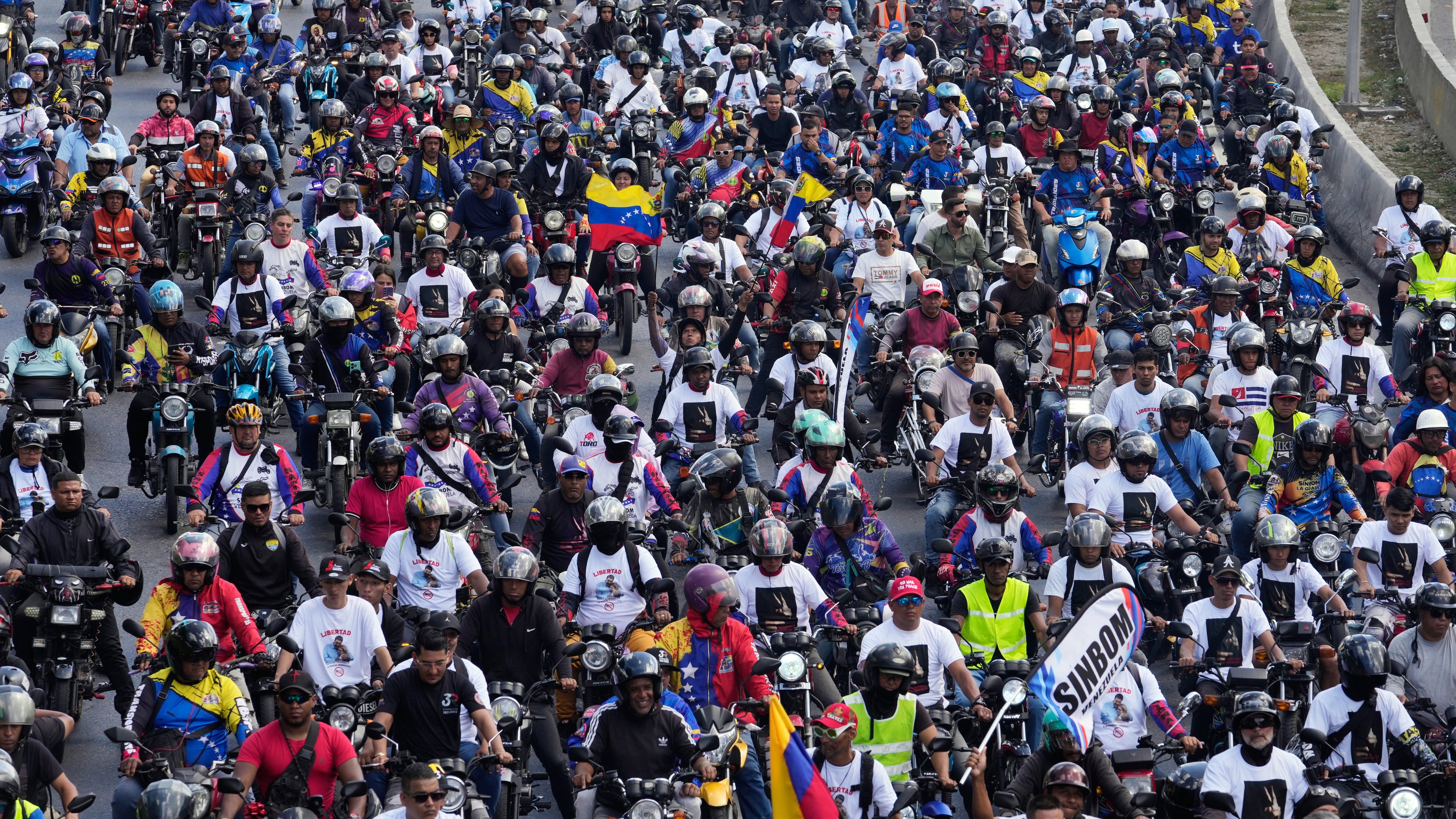 Supporters of former Venezuelan President Nicolas Maduro ride through the streets calling for his release as he faces trial in the United States after being captured by U.S. forces, in Caracas, Venezuela, Tuesday, Jan. 13, 2026. (AP Photo/Matias Delacroix)