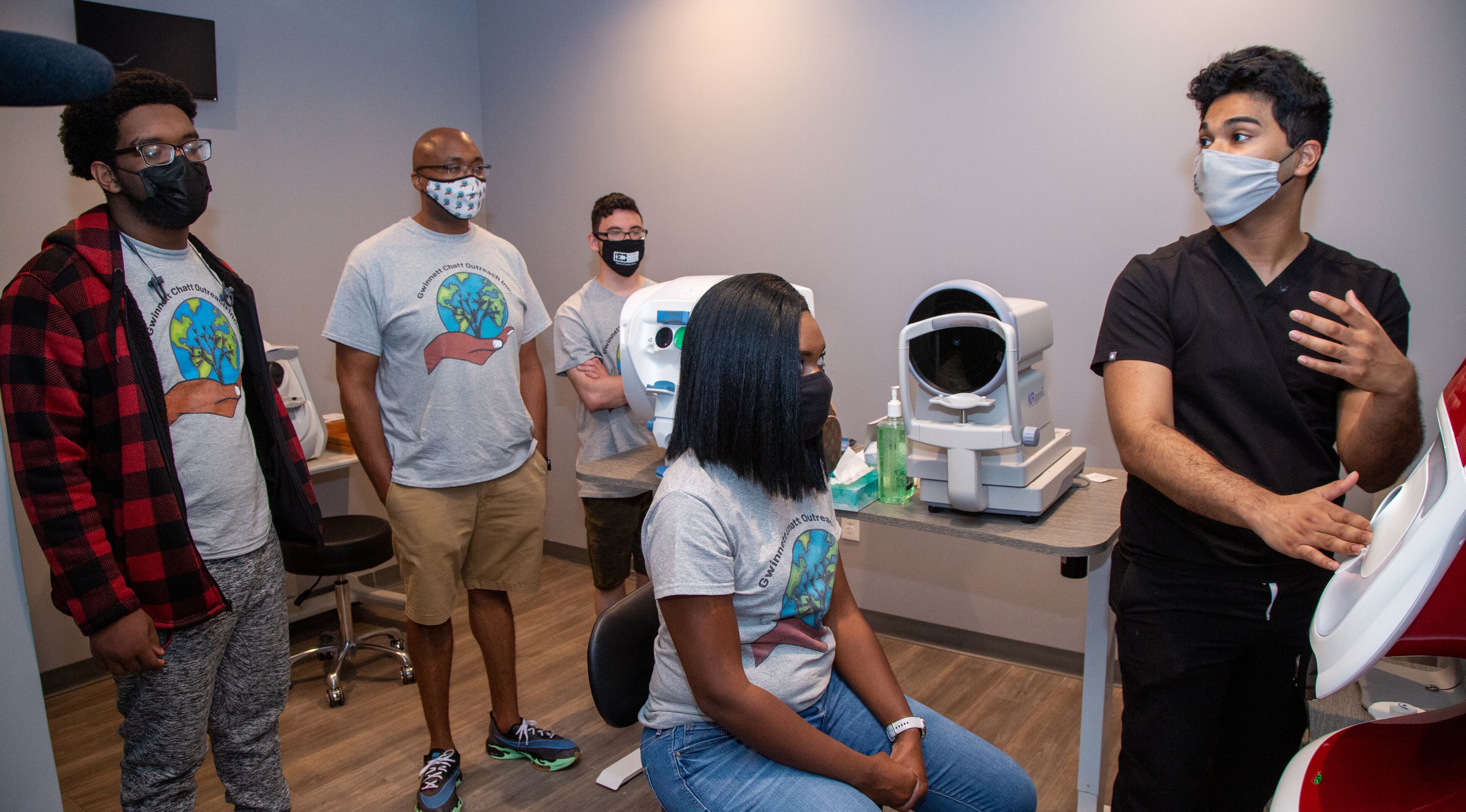 Kevin Freeman, Ryan Cox, Leonard Russell & LaShanta Cox (left to right) listen to Thasin Wahid explain an eye test machine at First Class Eye Care in Duluth. Ryan Cox founded the nonprofit Gwinnett Chatt Outreach last year that mostly donates food and other supplies and furthers community relations with the police. But one of its programs is called "Bridging the Gap," where he takes a group of high school students around to different businesses around Gwinnett County to show them different career opportunities.
PHIL SKINNER FOR THE ATLANTA JOURNAL-CONSTITUTION.