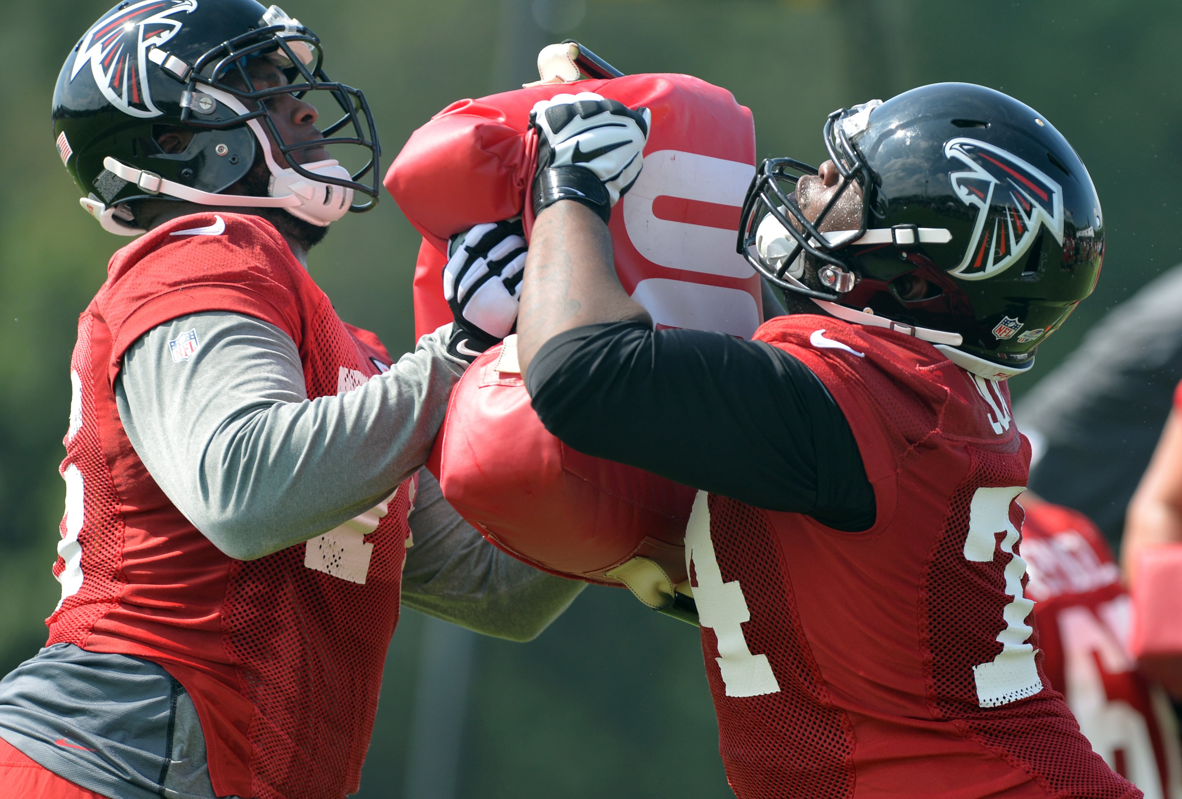 Atlanta Falcons tackles Lamar Holmes, left, and Terren Jones participate in drills during training camp on Friday, July 25, 2014.