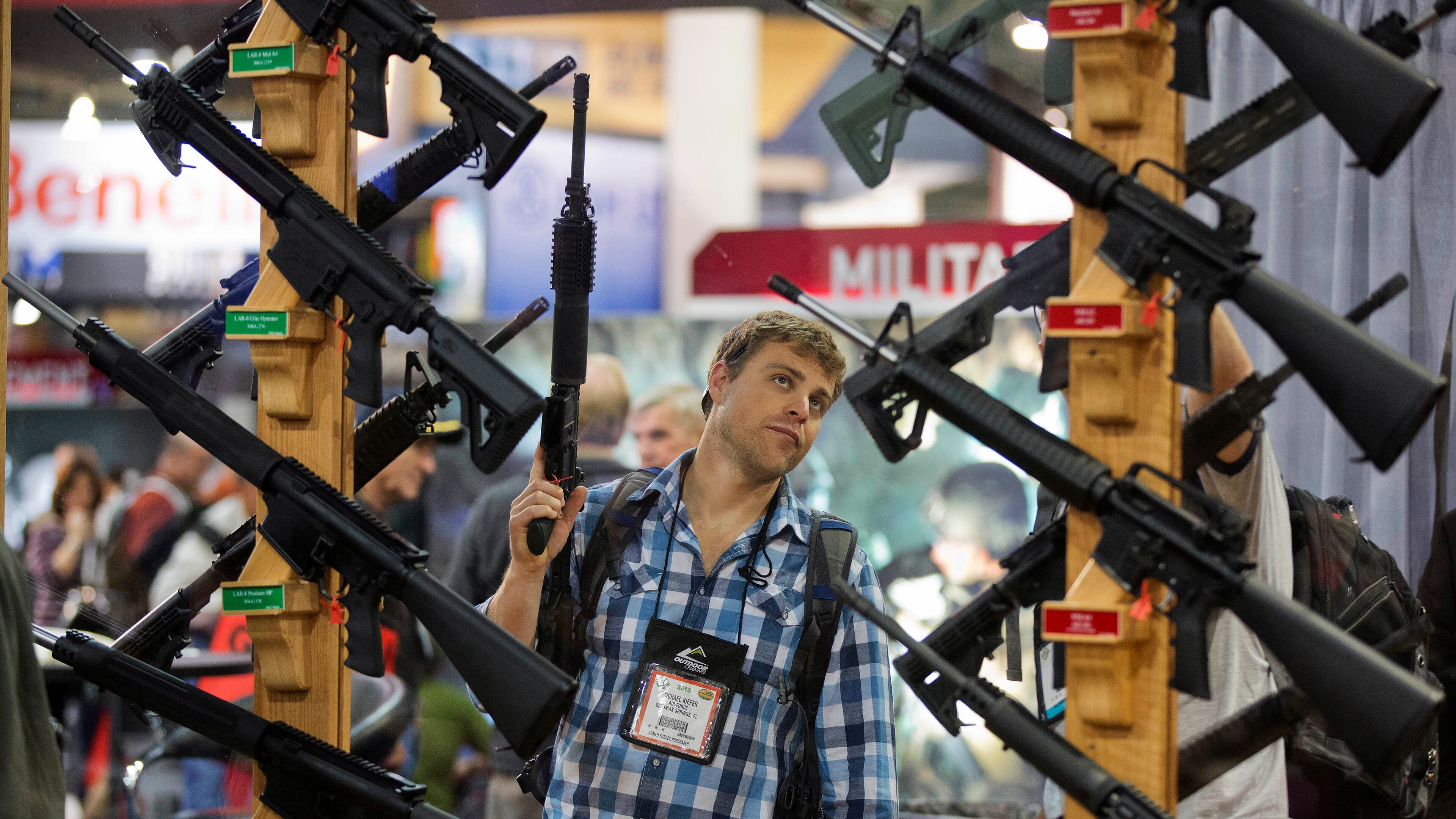 FILE - This Jan. 17, 2013 file photo shows Michael Kiefer of DeFuniak Springs, Fla., checking out a display of rifles at the Rock River Arms booth during the 35th annual SHOT Show in Las Vegas. Fresh off a victory in Washington state, a leading gun control group, Everytown for Gun Safety, has targeted Oregon as the next prize in a campaign to require all gun sales go through background checks to keep them from criminals, the mentally ill and domestic abusers. (AP Photo/Julie Jacobson)