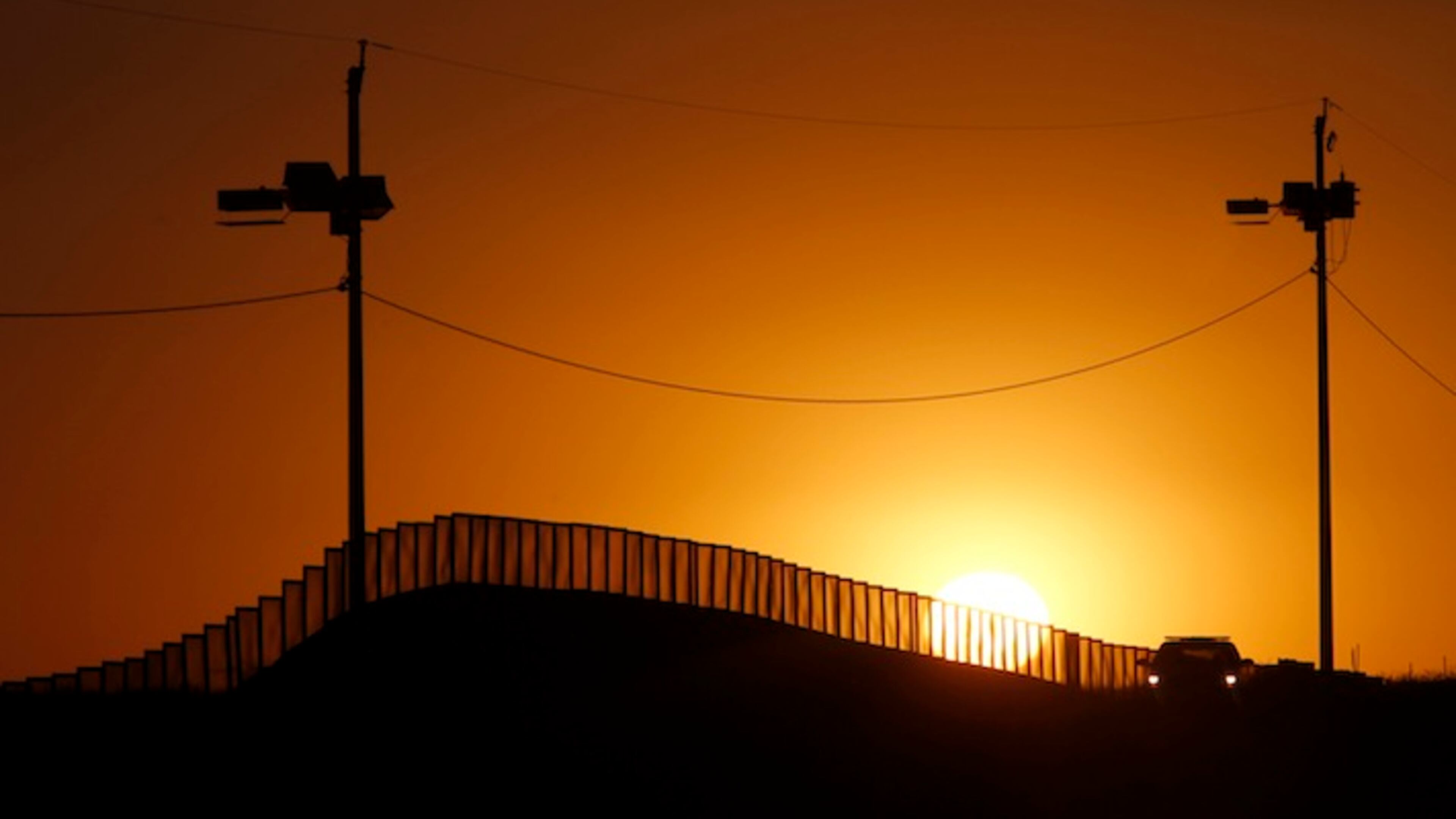 Sunset at the U.S.-Mexico border in Naco, Ariz., where a Border Patrol agent in his car keeps an eye on activity in a 2013 file image. President-elect Trump has vowed to begin construction on the wall soon after his January 20, 2017, inauguration. (Don Bartletti/Los Angeles Times/TNS)
