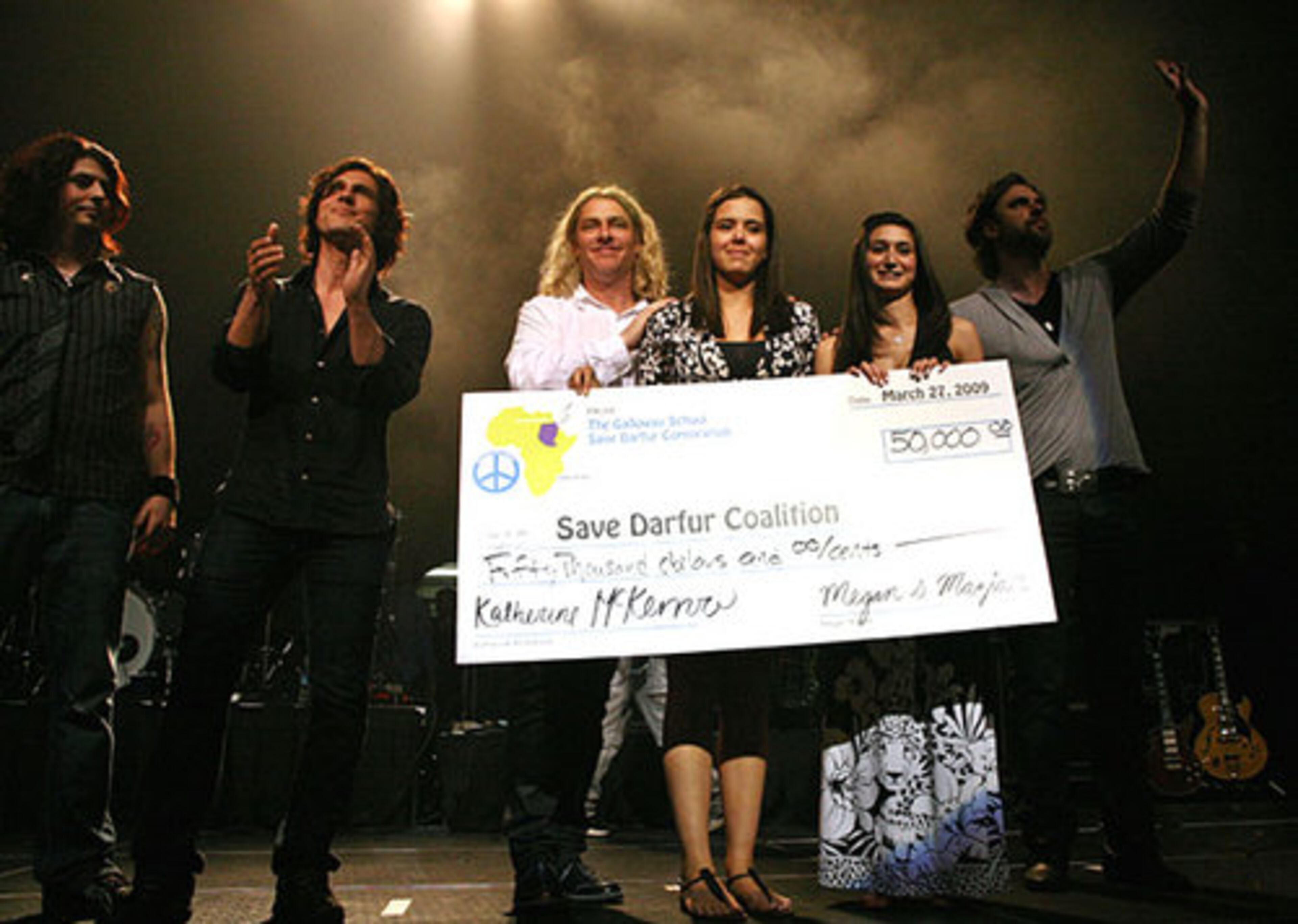Members of Collective Soul present organizers Katherine McKerrow (third from right) and Megan Maziar with a check for $50,000 from the show's proceeds. The annual benefit concert was created in 2007 by a group of students at The Galloway School in Atlanta, under the leadership of teacher Lexi Hunter.
