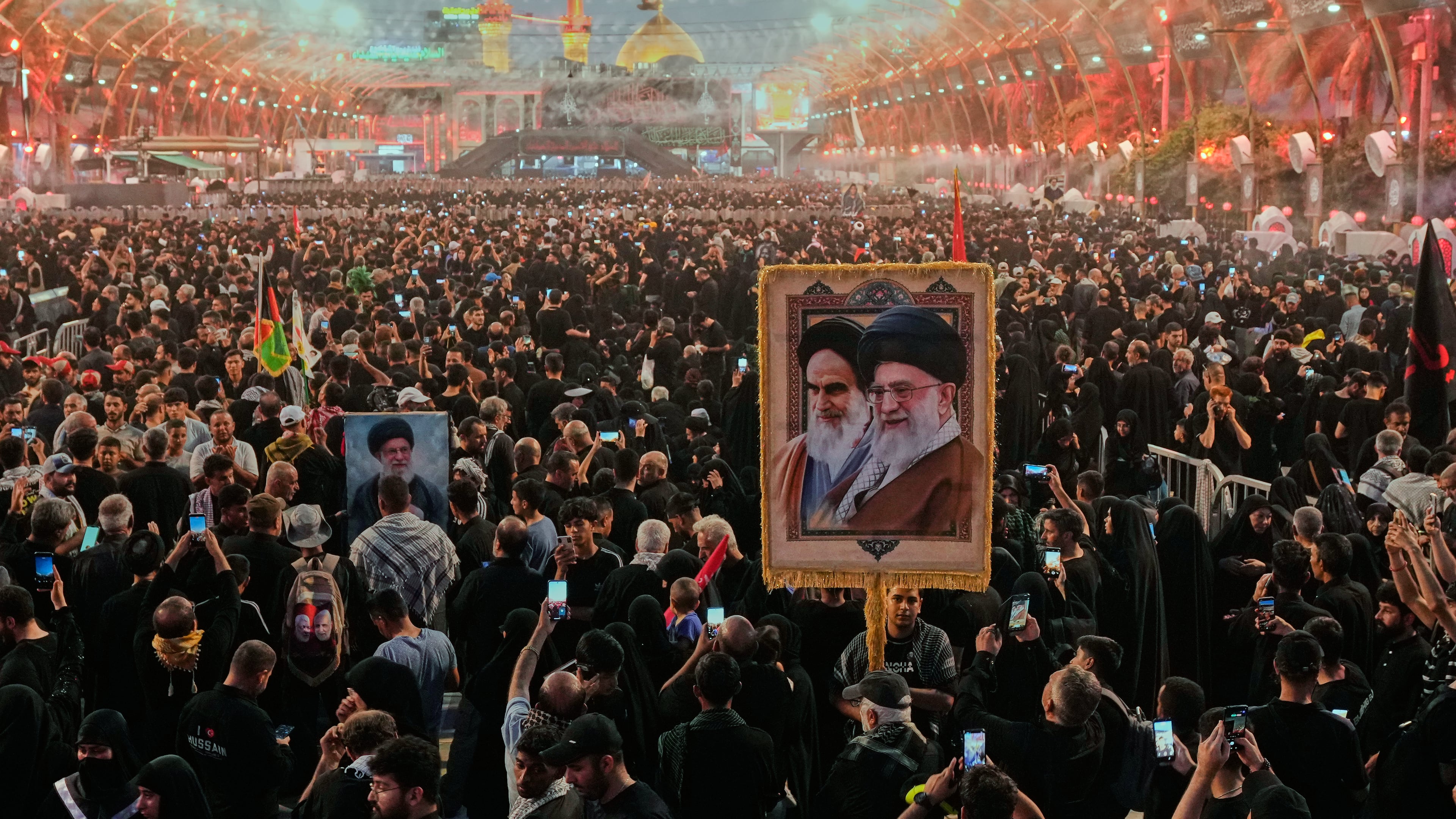 Shiite worshipers carrying a portrait of the late Iranian Supreme Leader Ayatollah Ali Khamenei and the late Iranian Leader Ayatollah Khomeini gather between the holy shrines of Imam Abbas and Imam Hussein during Arbaeen, marking the end of the 40-day mourning period following Ashoura, in Karbala, Iraq, Tuesday, Aug. 4, 2026. (AP Photo/Hadi Mizban)