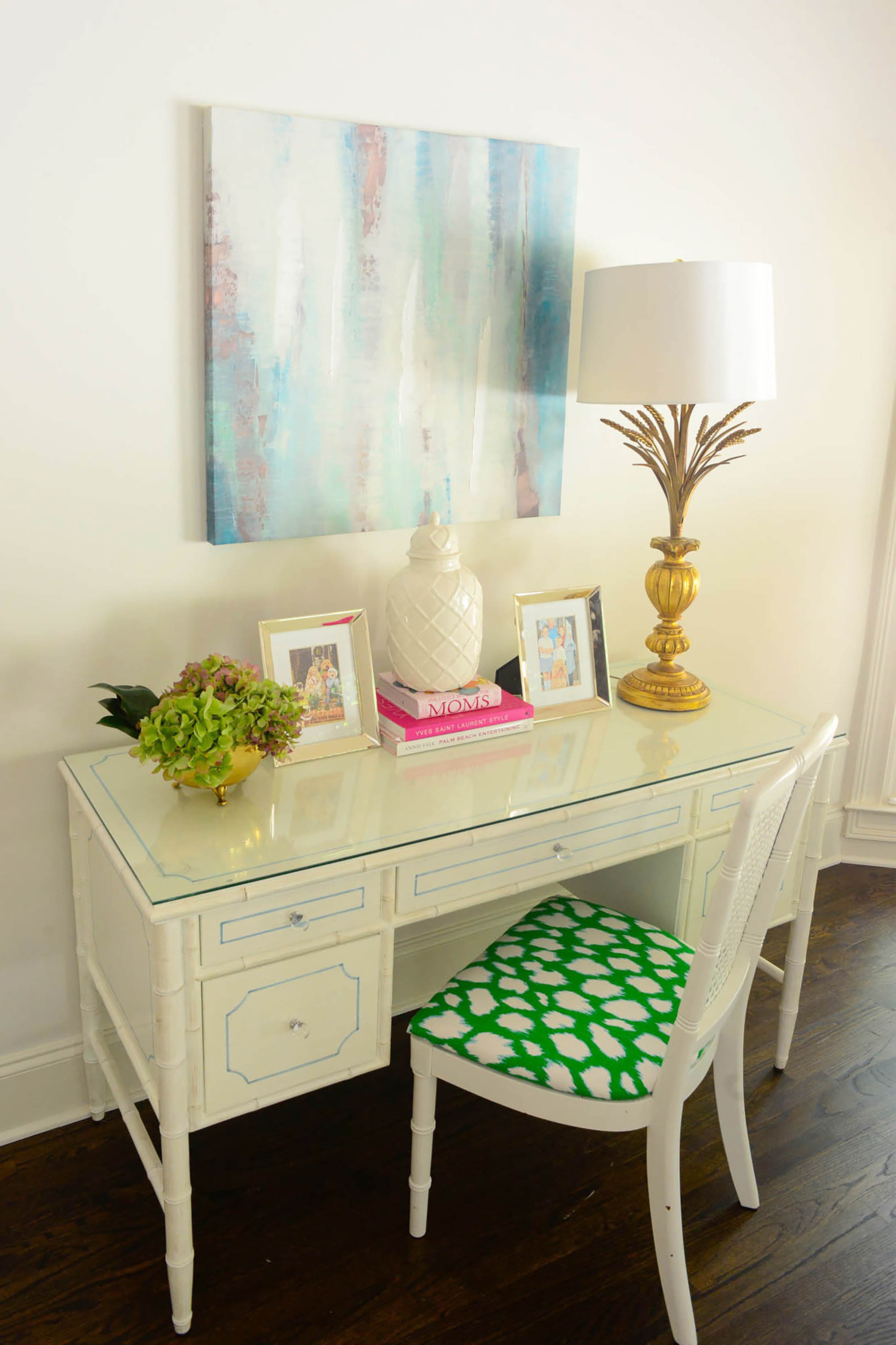 A gold lamp reminiscent of a palm tree, and bamboo-detailed desk and chair from AmericasMart Atlanta are examples of Edee's Palm Beach Regency style in the master bedroom.
