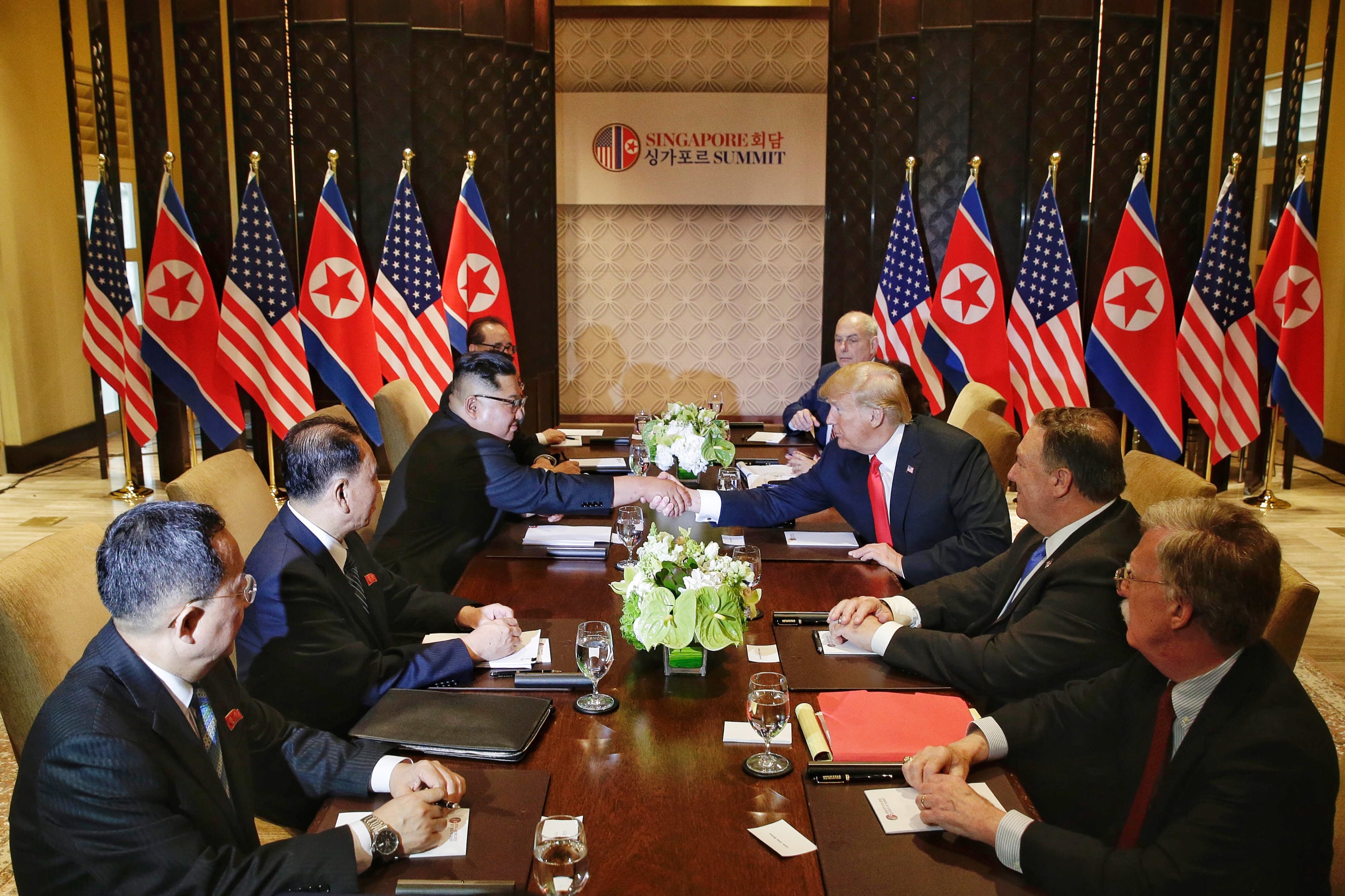 SINGAPORE - JUNE 12: In this handout photo, North Korean leader Kim Jong-un (L) shakes hands with U.S. President Donald Trump during their historic U.S.-DPRK summit at the Capella Hotel on Sentosa island on June 12, 2018 in Singapore. U.S. President Trump and North Korean leader Kim Jong-un held the historic meeting between leaders of both countries on Tuesday morning in Singapore, carrying hopes to end decades of hostility and the threat of North Korea's nuclear program. (Photo by Kevin Lim/THE STRAITS TIMES/Handout/Getty Images)