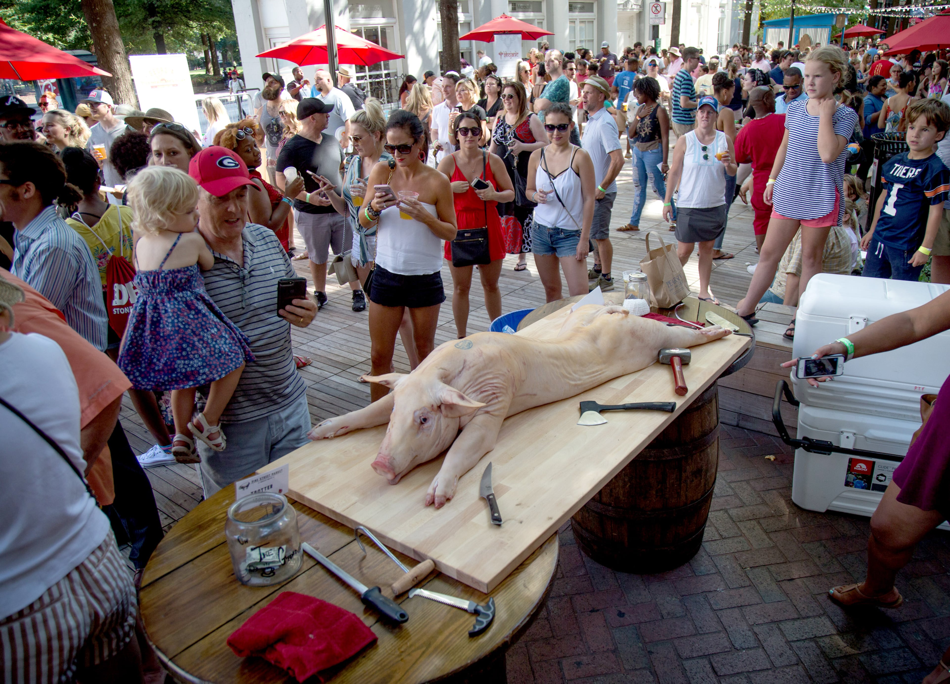 PEACHFEST: A pig is laid out before it is butchered during the PeachFest in Atlanta, Ga., July 29, 2018. The non-profit festival supports the growth of family farms and producers. Proceeds benefit Piggy Bank, farm-in-the-making that will help launch family farms by providing heritage breed piglets and access to business plans. The festival returned to downtown Atlanta for its second year. STEVE SCHAEFER / SPECIAL TO THE AJC