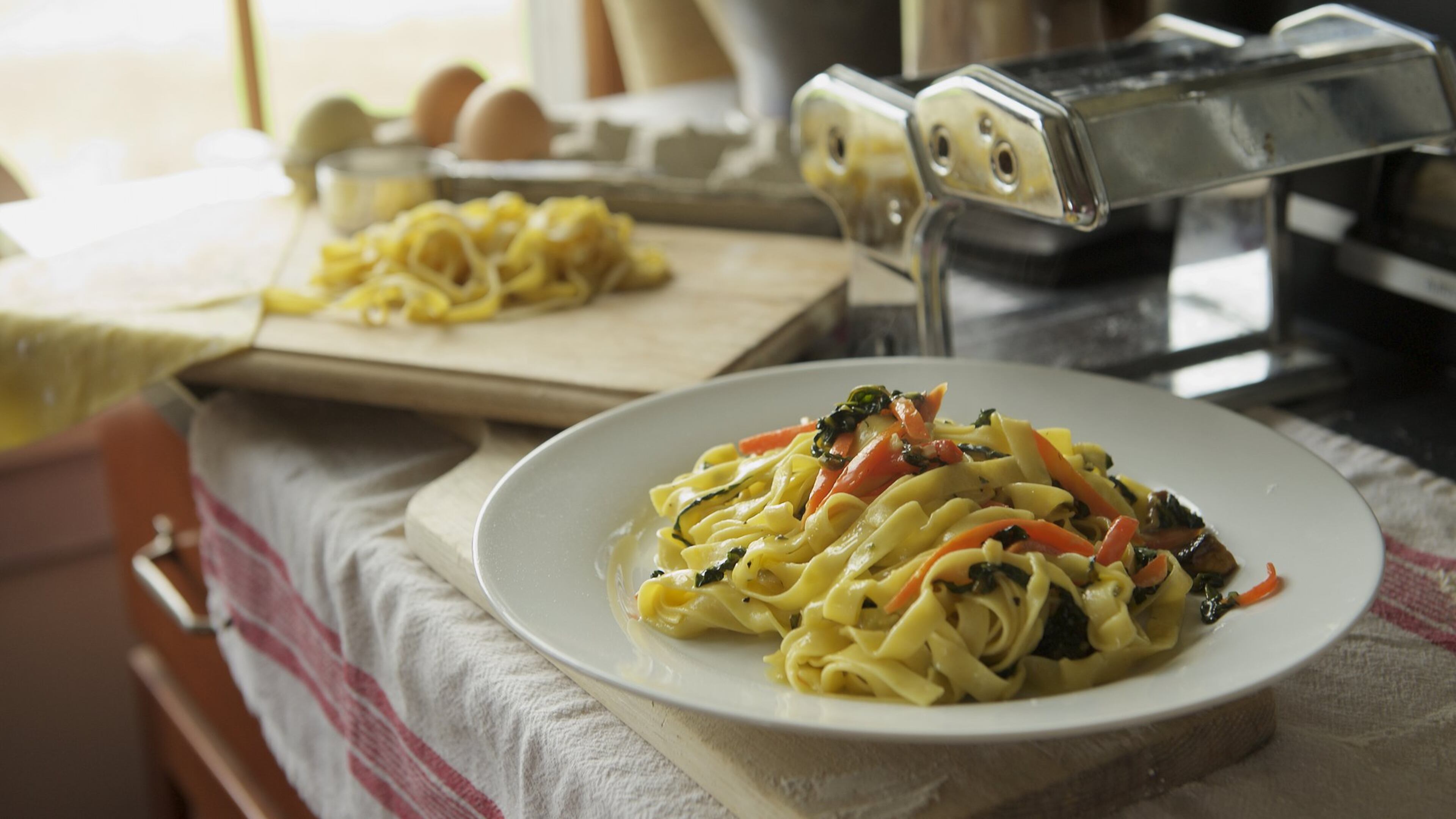 Veggie Carbonara features homemade fettucine, kale, carrots and a rich sauce of cream, Asiago, egg yolks and fresh oregano. Photo credit: Tom Brodnax. Styling credit: Laurie and Will Moore