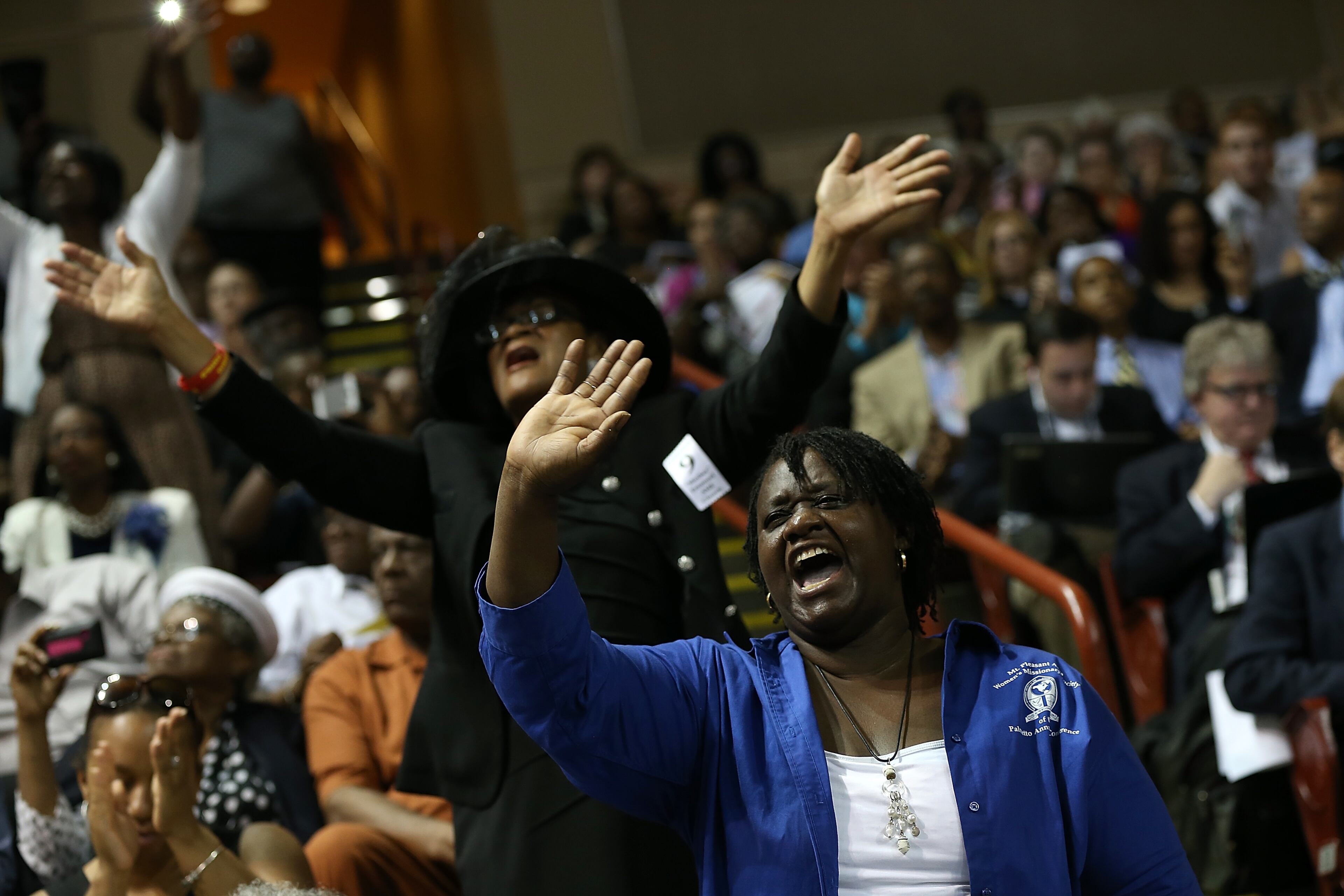 CHARLESTON, SC - JUNE 26: Mourners sing gospel hymns during the funeral service where U.S. President Barack Obama will deliver the eulogy for South Carolina State senator and Rev. Clementa Pinckney who was killed along with eight others in a mass shooting June 26, 2015 in Charleston, South Carolina. Suspected shooter Dylann Roof, 21, is accused of killing nine people on June 17th during a prayer meeting in the church, which is one of the nation's oldest black churches in Charleston. (Photo by Win McNamee/Getty Images)