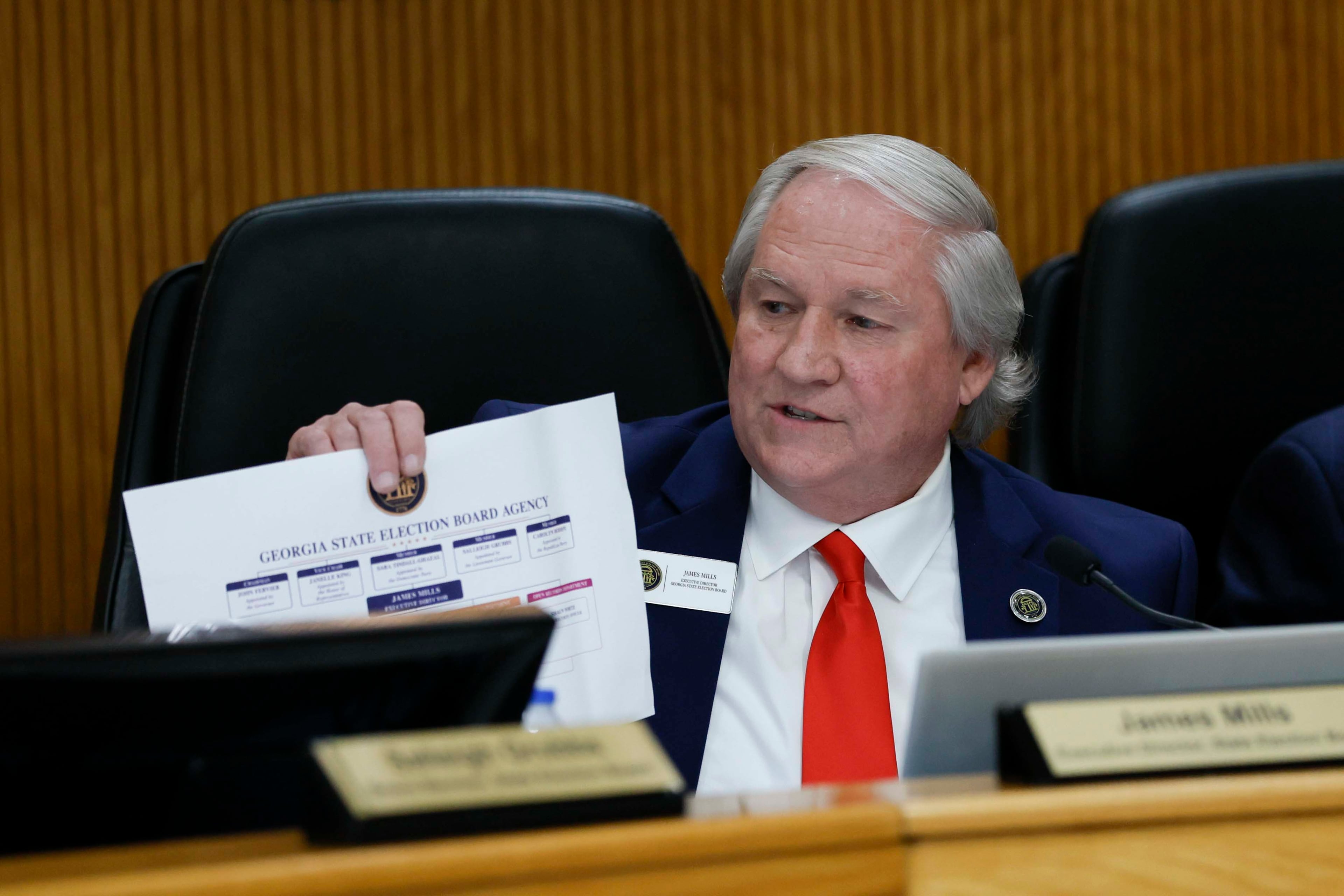 Executive Director of the State Elections Board, James Mills, displays a document during the State Elections Board meeting at the Fayette County Administration Complex on Wednesday, August 19, 2026. (Miguel Martinez/AJC)