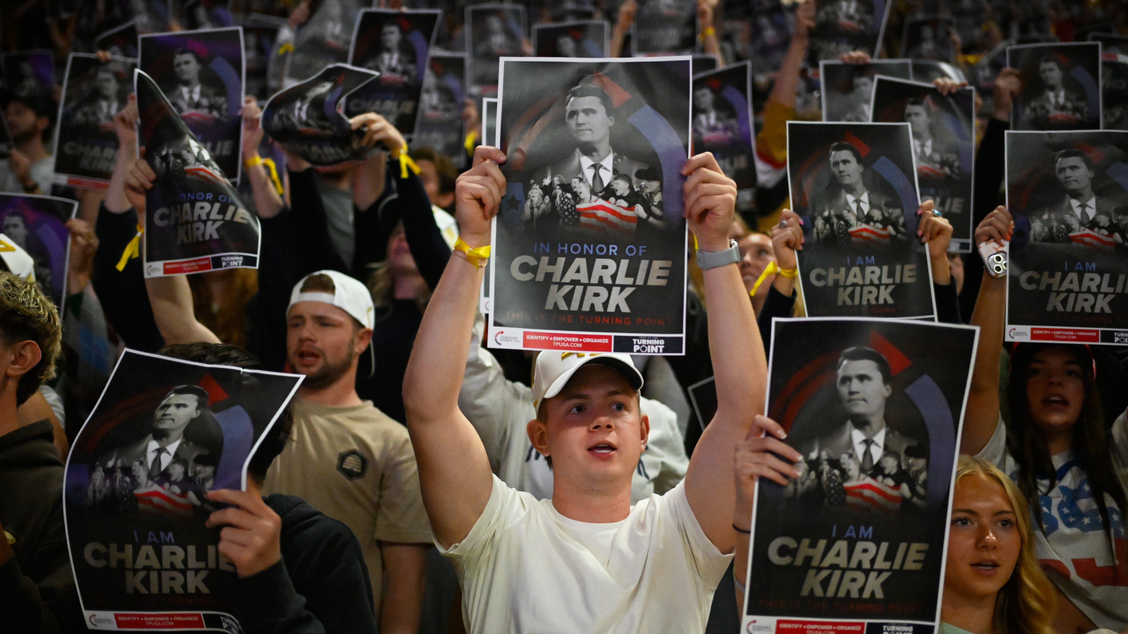 People hold posters of Charlie Kirk during a Turning Point USA rally at Utah State University, as a part of the organization's push to memorialize Kirk on Tuesday, Sept. 30, 2025, in Logan, Utah. (Alex Goodlett/AP)