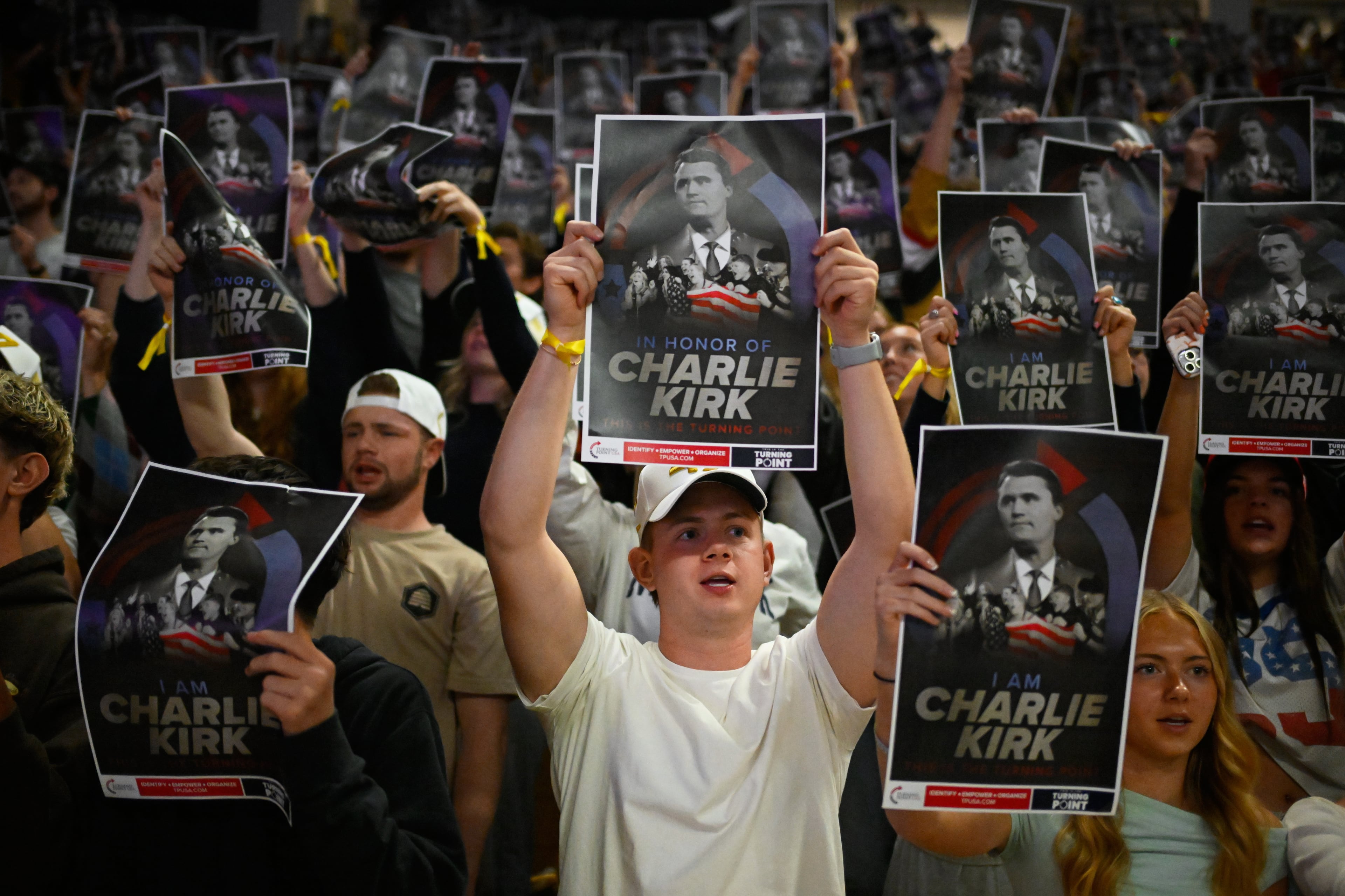 People hold posters of Charlie Kirk during a Turning Point USA rally at Utah State University, as a part of the organization's push to memorialize Kirk on Tuesday, Sept. 30, 2025, in Logan, Utah. (Alex Goodlett/AP)