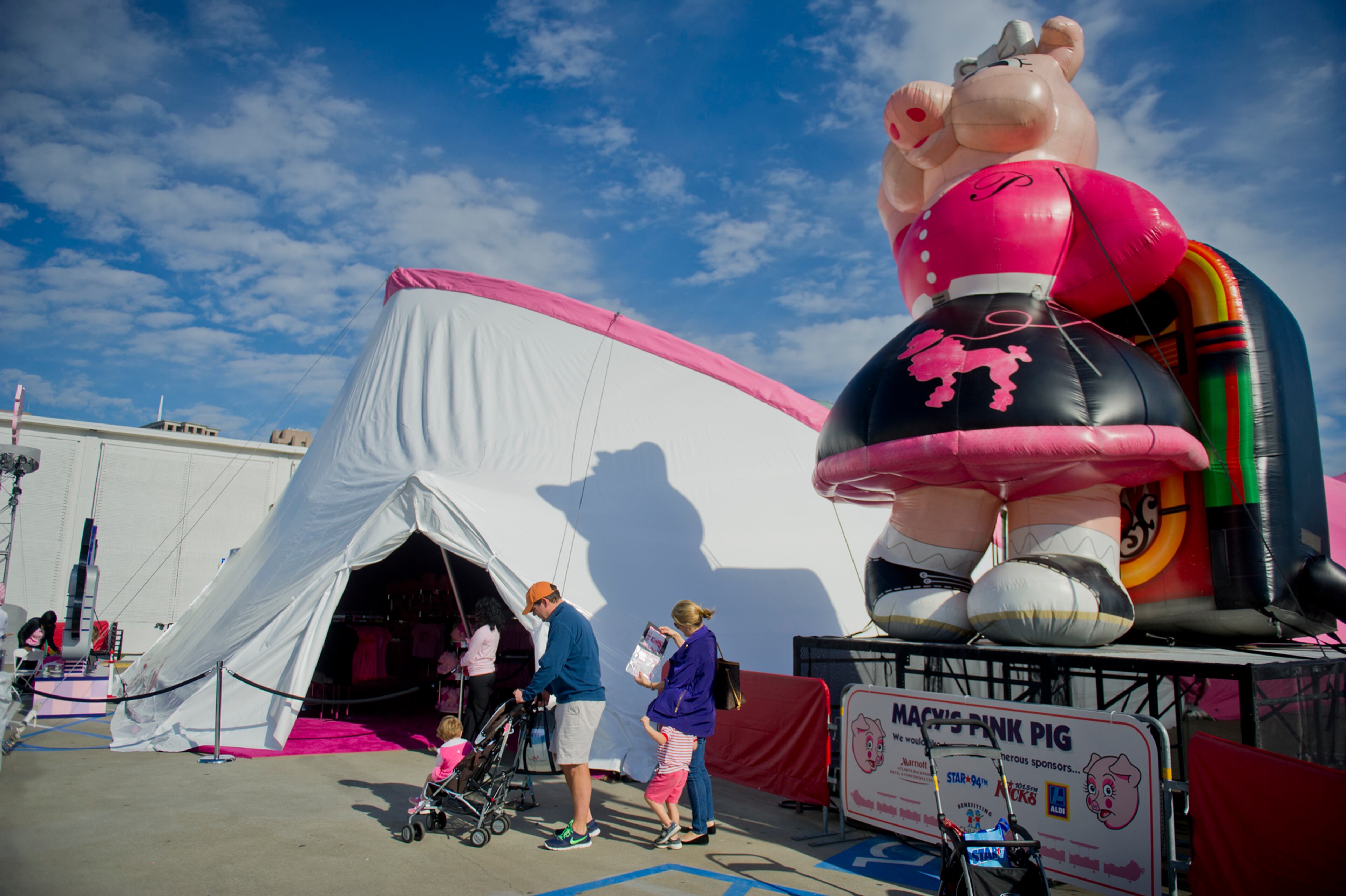 Lane Moore (left) leads his family away from Priscilla the Pink Pig at Lenox Square Mall in Buckhead after riding the short train on Nov. 2, 2013.
